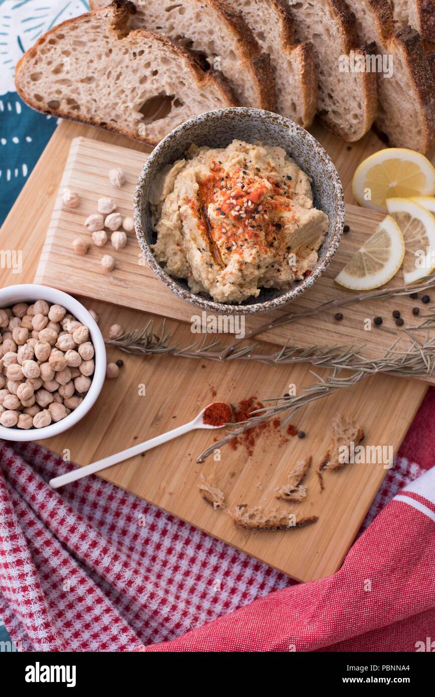 Hummus con integrale pane di pasta acida, paprica e limone Foto Stock