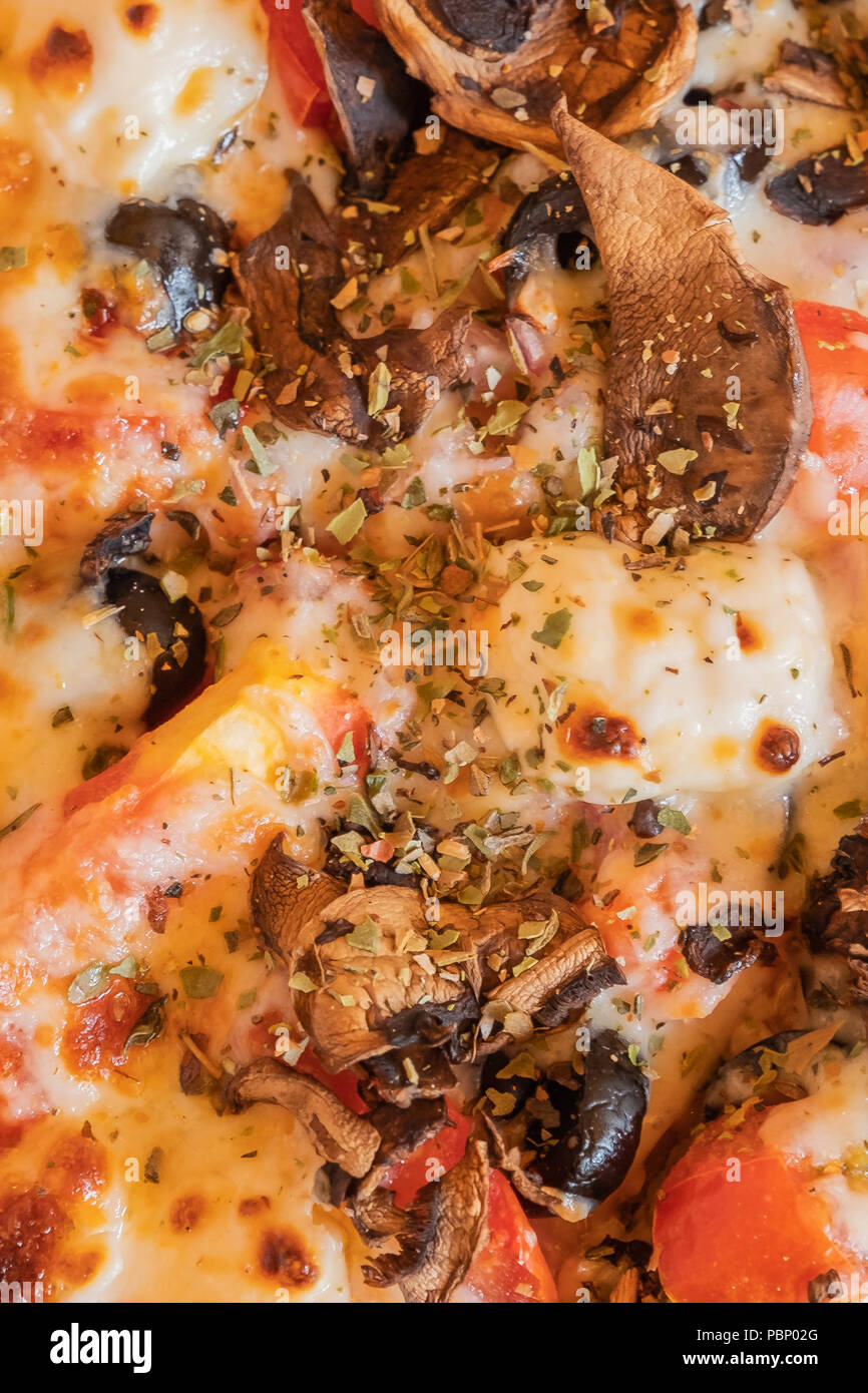 Parte della pizza italiana con formaggio, olive e funghi prese un close-up. Foto Stock