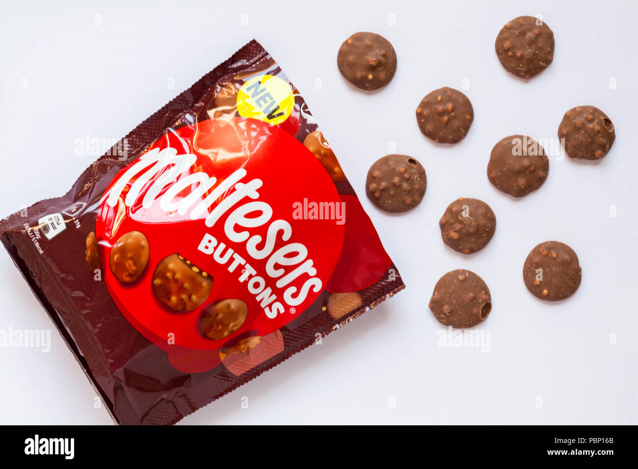 Pacchetto di Maltesers pulsanti aprono con contenuto versato set versato su sfondo bianco - poco cioccolato al latte Tondi riempiti con pezzi di malto Foto Stock