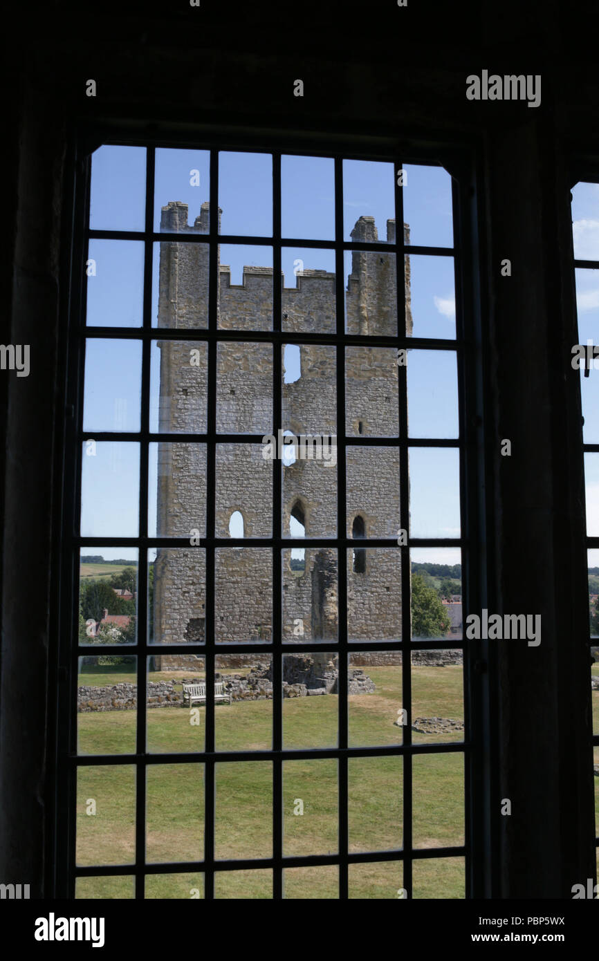 Il XII secolo torre est del Castello di Helmsley visto attraverso la sua Tudor Mansion della finestra Foto Stock