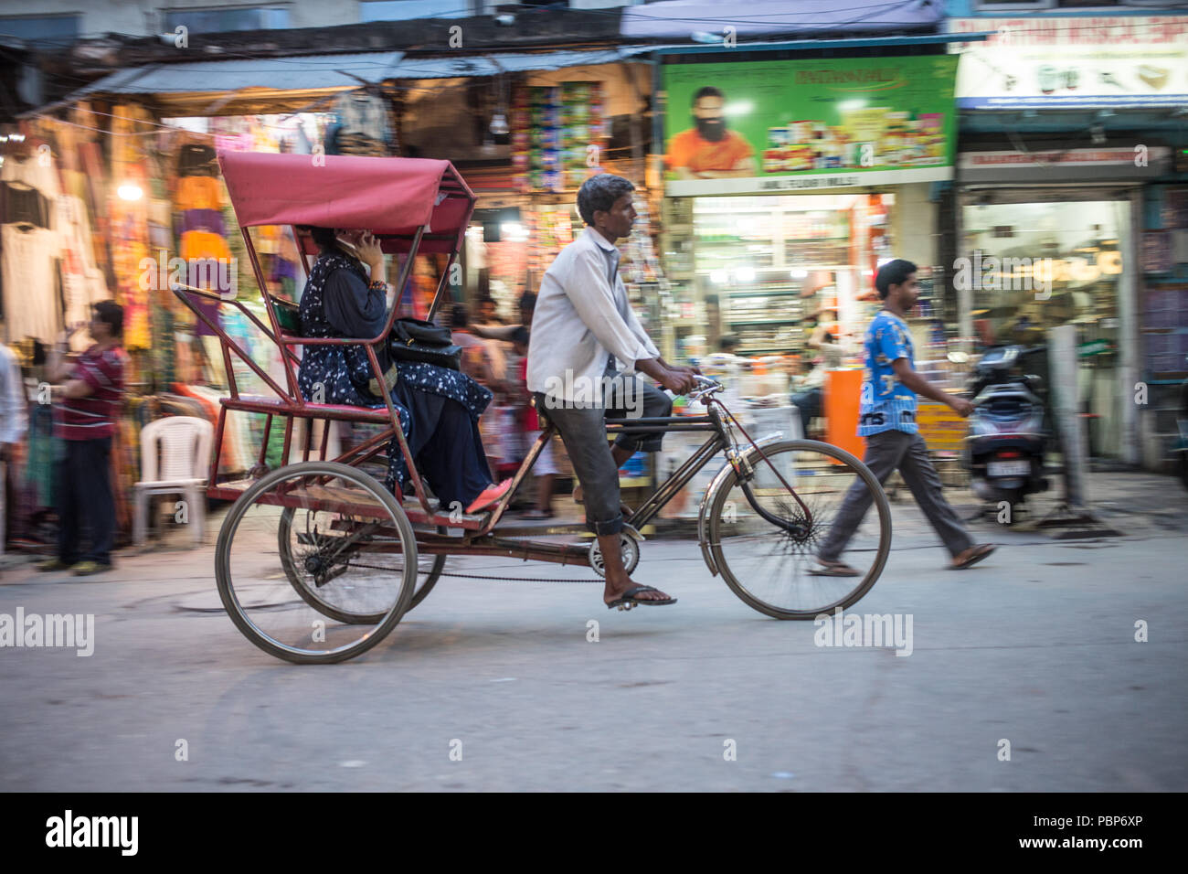 Risciò bicicletta cercando di guidare il cliente attraverso le strade affollate del centro di Nuova Delhi. Foto Stock