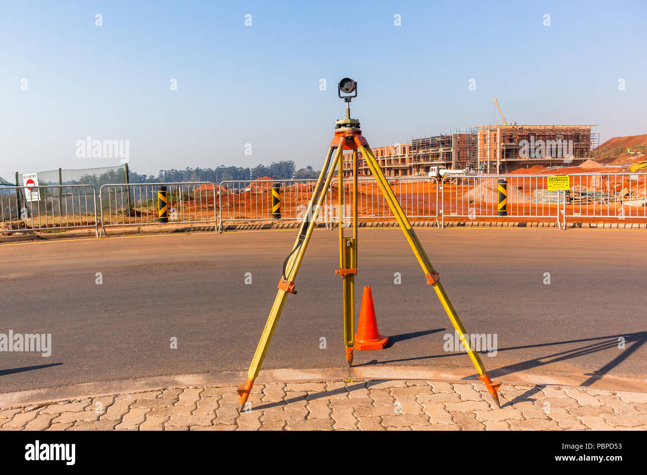 Costruzione cantiere paesaggio con agrimensura treppiede e portata di misura attrezzo su strada Foto Stock