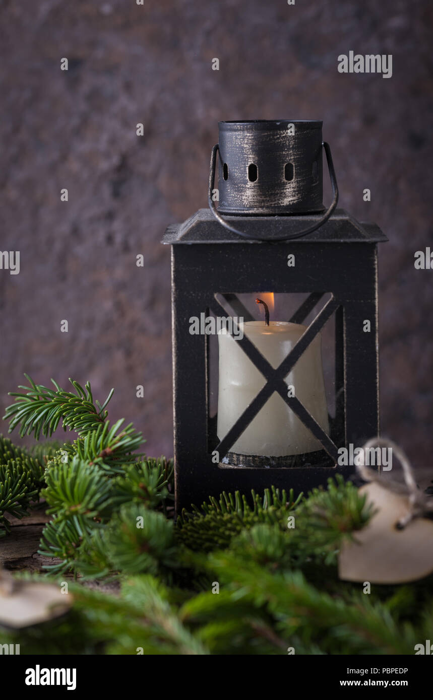 Composizione di natale con candela lanterna e abeti bianchi su sfondo scuro Foto Stock