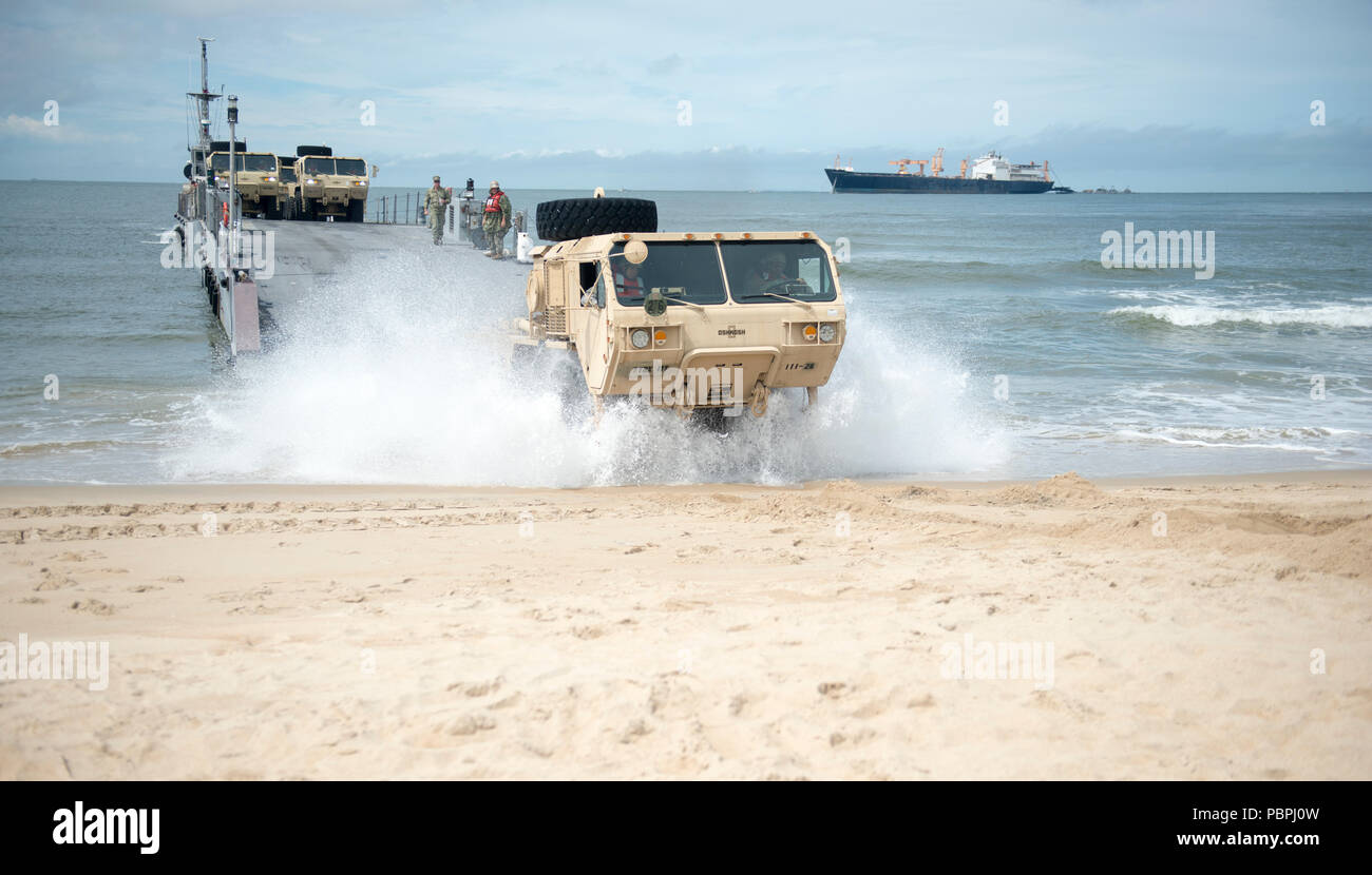 VIRGINIA BEACH, Va. (25 luglio 2018) i soldati dal xi battaglione di trasporto guidare il proprio veicolo su Utah Beach a bordo comune Base Expeditionary Little Creek - Fort Story dopo lo sbarco da un Marina migliorato sistema di alleggio (INLS) Causeway traghetto, pur partecipando in esercizio Trident Sun 18. Trident Sun 18 è un preposizionamento marittima forza (MPF) operazione destinata a fornire una formazione alla componente di riserva personale per quanto riguarda il flusso in offload di veicoli e attrezzature militari. (U.S. Foto di Marina di Massa Specialista comunicazione marinai Giacobbe Vermeulen) Foto Stock