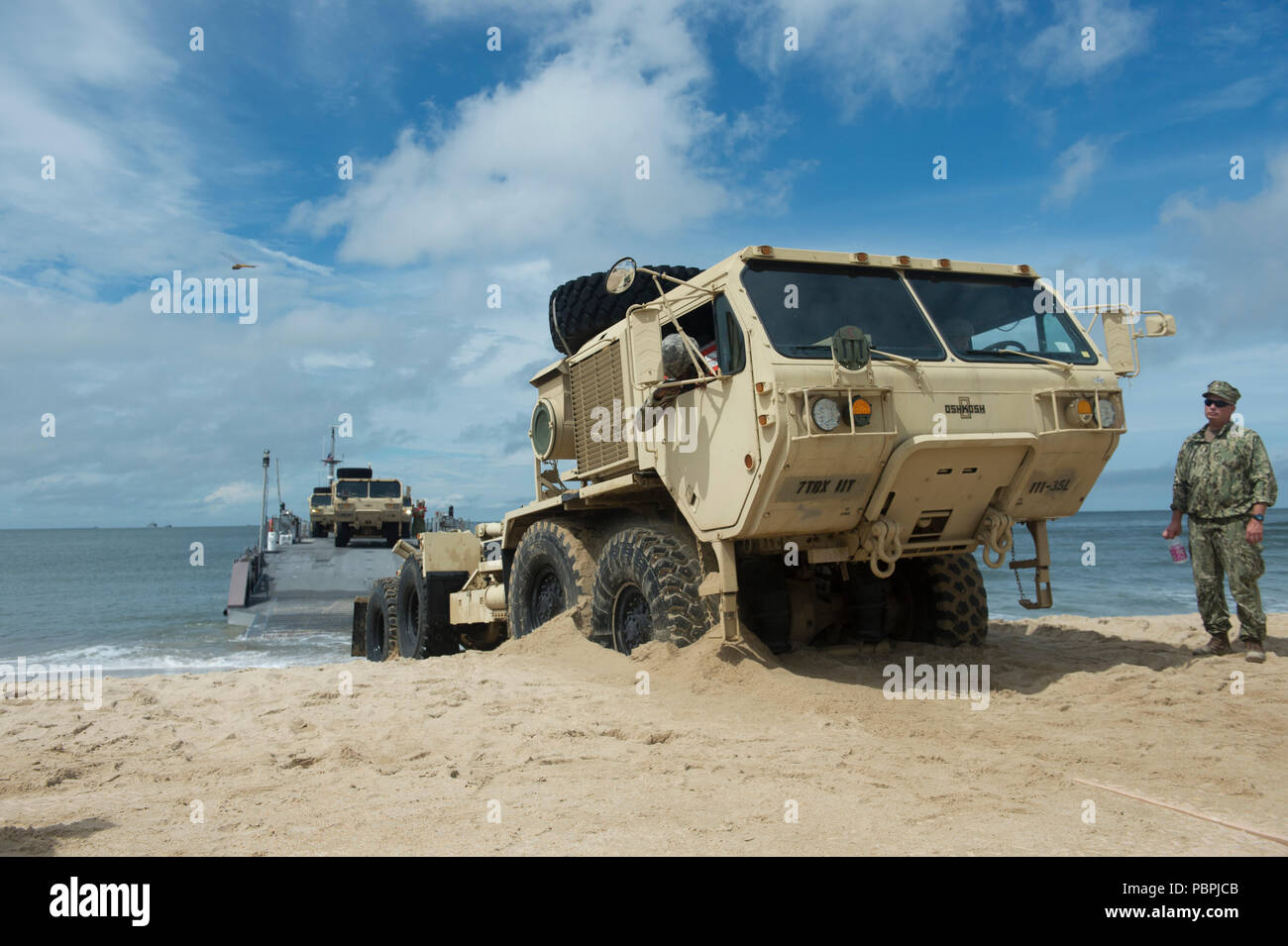 VIRGINIA BEACH, Va. (25 luglio 2018) UN U.S. Esercito Oshkosh pesanti Mobilità Estesa Tactical carrello aziona su Utah beach dopo lo sbarco di una marina migliorato sistema di alleggio (INLS) Causeway traghetto mentre partecipa in esercizio Trident Sun 18 a bordo comune Base Expeditionary Little Creek - Fort Story. Trident Sun 18 è un preposizionamento marittima forza (MPF) operazione destinata a fornire una formazione alla componente di riserva personale per quanto riguarda il flusso in offload di veicoli e attrezzature militari. (U.S. Foto di Marina di Massa lo specialista di comunicazione 2a classe Kenneth Gardner). Foto Stock