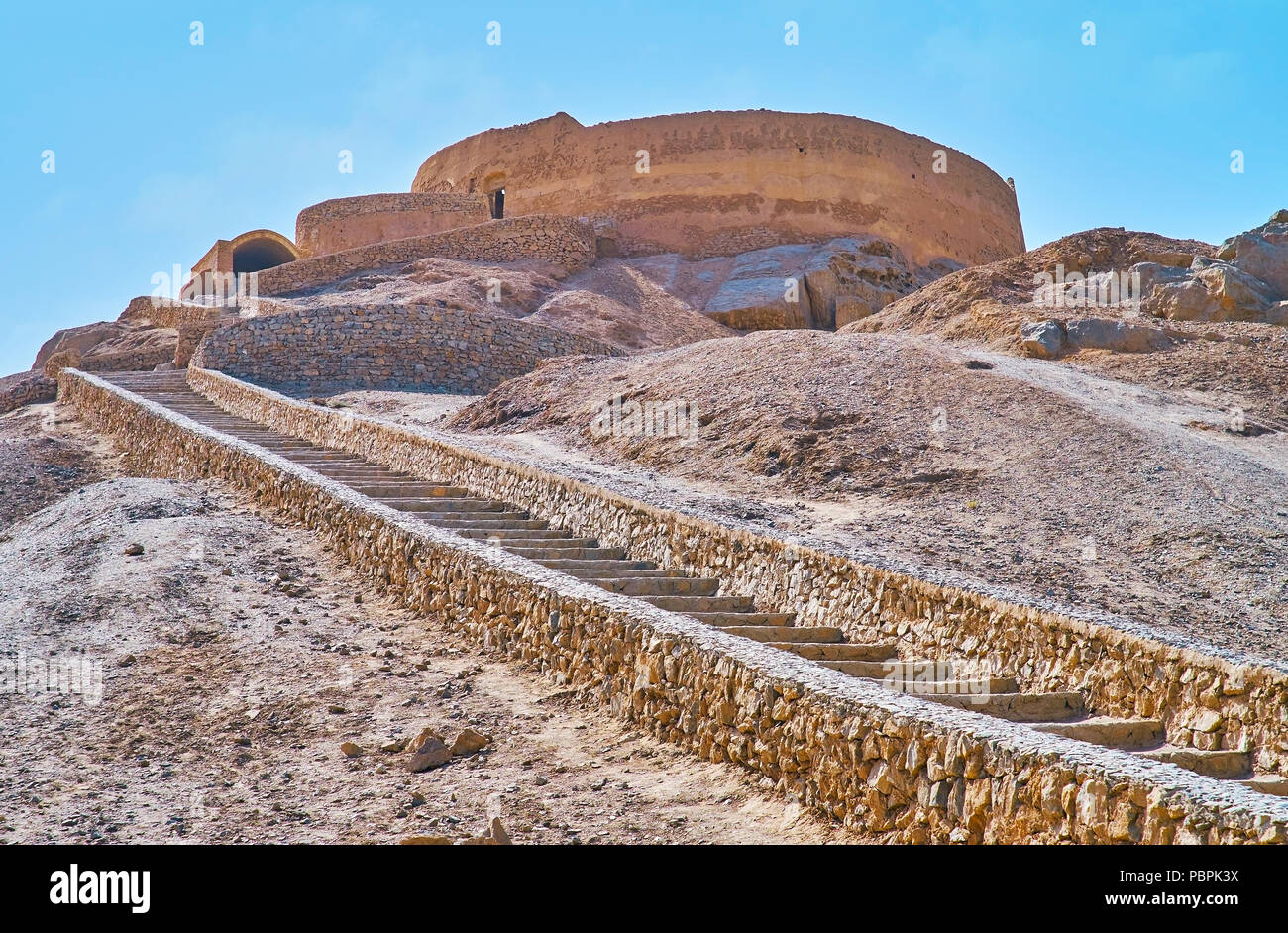 La curva stretta scalinata in pietra che conduce alla sommità della roccia con conserva di Torre di silenzio - luogo zoroastriana di rituali di sepoltura, Yazd, Iran. Foto Stock