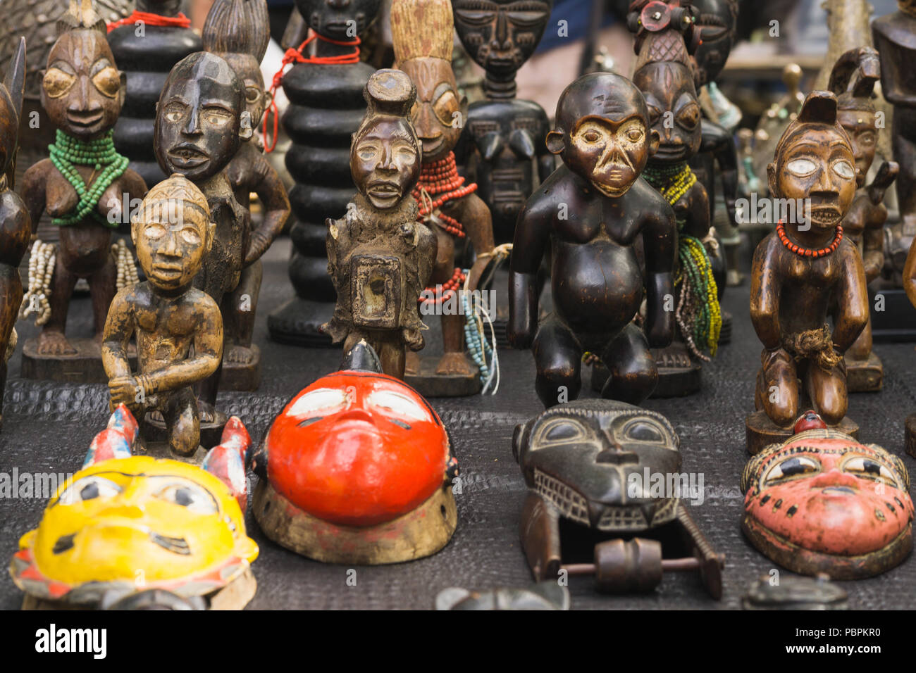 Le maschere africane in vendita - tradizionali maschere africane venduti al mercato delle pulci di Parigi, in Francia, in Europa. Foto Stock