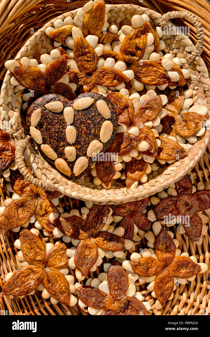 Fig e mandorla 'estrelas' dolci specialità regionale dell'Algarve, in un ambiente rustico cestello realizzato da tessuti palm-foglie. Portogallo Foto Stock