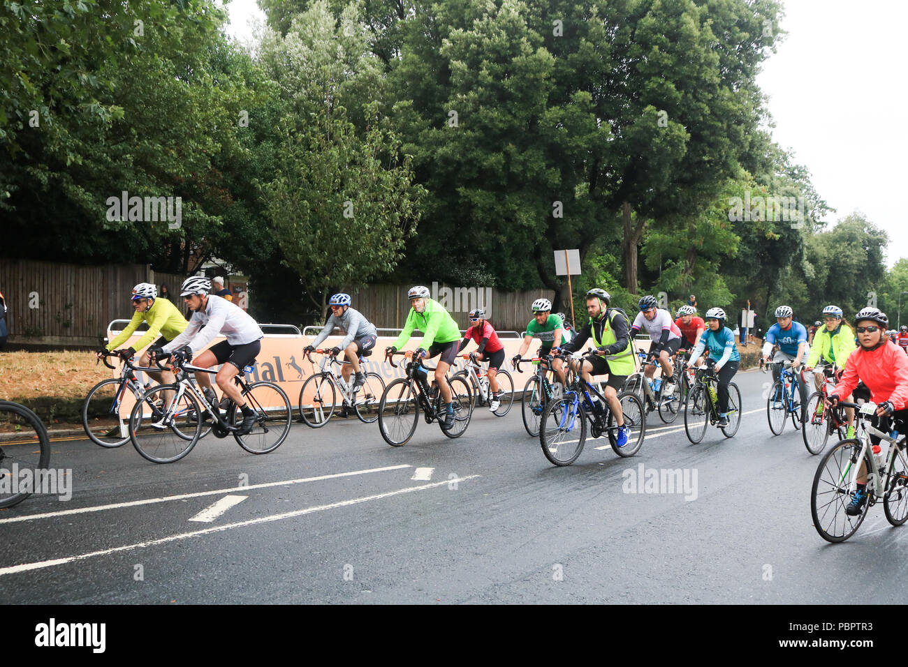 Londra REGNO UNITO. Il 29 luglio 2018. Migliaia di ciclisti ride through Wimbledon Village nel Prudential Londra Surrey 100 evento classico su un nuvoloso giorno di pioggia . Il prudenziale Ride London-Surrey 100 nel suo sesto anno celebra il retaggio per il ciclismo creato dal London 2012 Giochi Olimpici e Paraolimpici e segue un 100-miglio percorso su strade chiuse attraverso la capitale e nella campagna del Surrey Credito: amer ghazzal/Alamy Live News Foto Stock