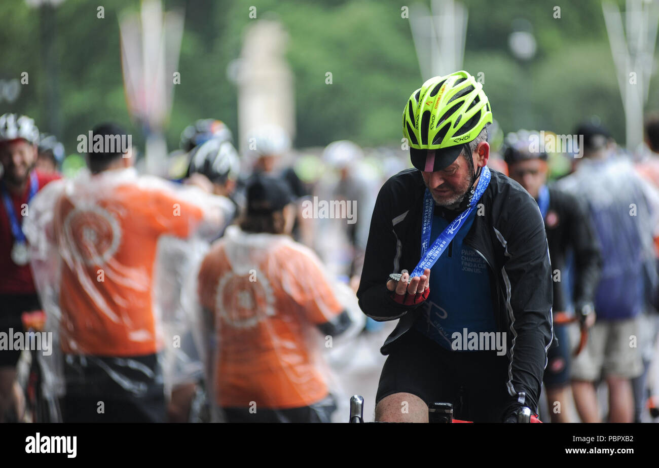 Londra, UK, 29 luglio 2018. Prudential RideLondon-Surrey 100. Un cavaliere ammira la sua medaglia sul Mall dopo aver completato la London - Surrey 100, che vede 26.000 ciclisti amatoriali prendere su di una sfida ciclistica come nessun altro attraverso Londra e Surrey su un percorso simile a quello di Londra 2012 Olympic Road gare, come parte di Prudential RideLondon Festival di fine settimana in bicicletta. @ David Partridge / Alamy Live News Foto Stock