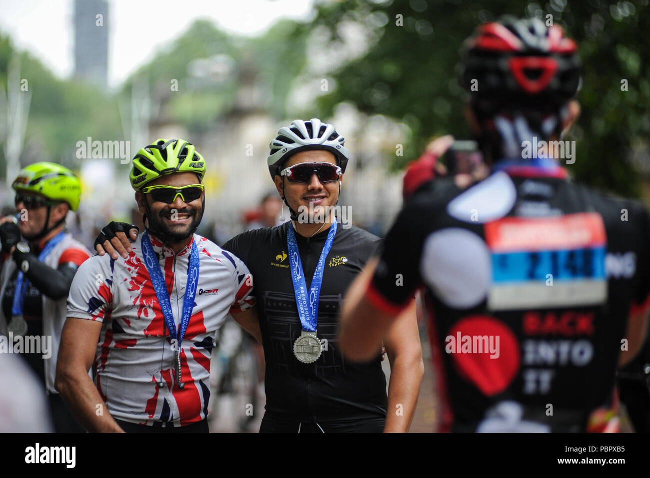 Londra, UK, 29 luglio 2018. Prudential RideLondon-Surrey 100. Rider posano per le foto con le loro medaglie sul Mall dopo aver completato la London - Surrey 100, che vede 26.000 ciclisti amatoriali prendere su di una sfida ciclistica come nessun altro attraverso Londra e Surrey su un percorso simile a quello di Londra 2012 Olympic Road gare, come parte di Prudential RideLondon Festival di fine settimana in bicicletta. @ David Partridge / Alamy Live News Foto Stock