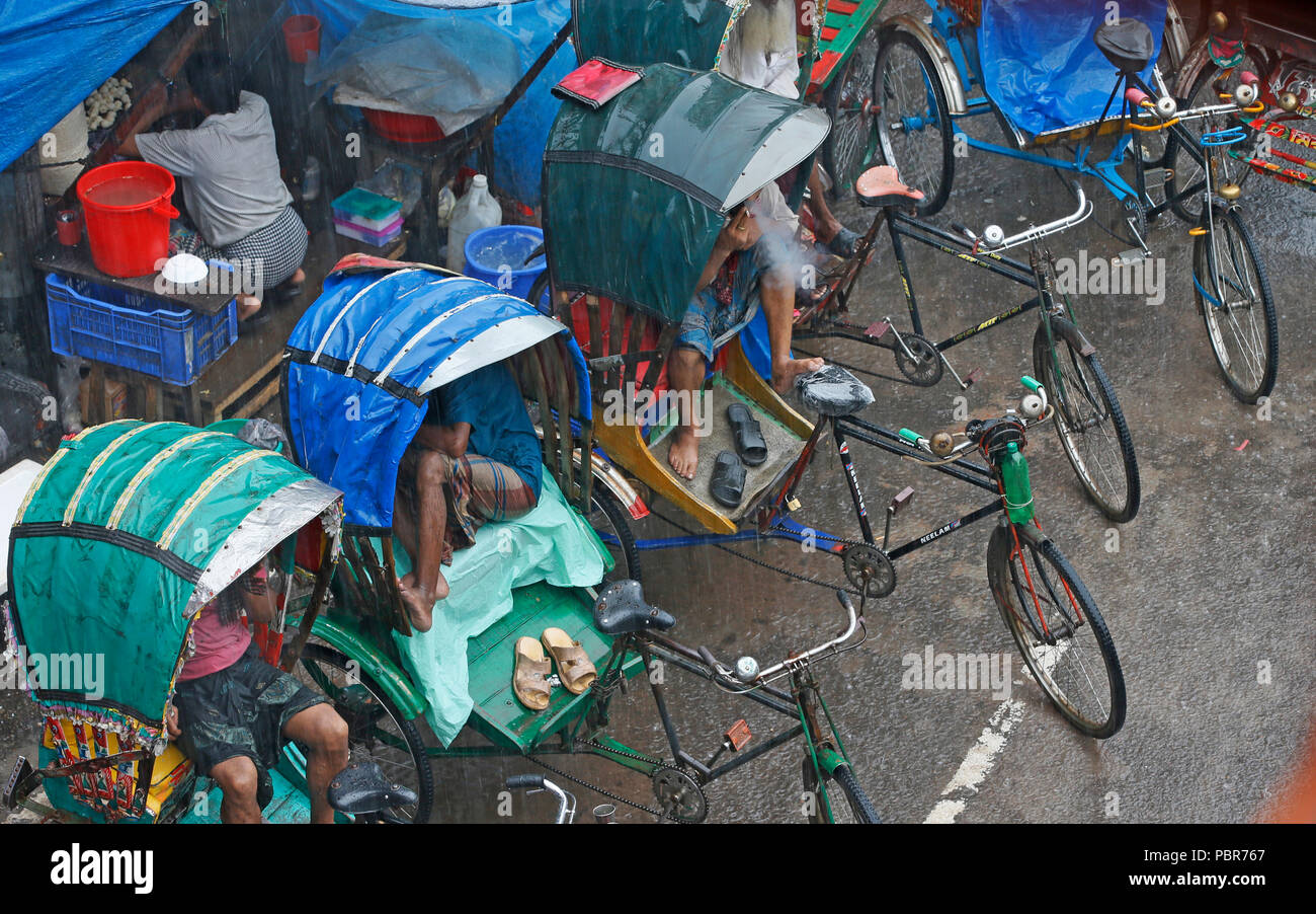 Abitanti della città catturati nella doccia pesante a capitale Purana Paltan area vicino National Baitul Mukarram moschea, Dhaka, Bangladesh. Luglio 24, 2018 Foto Stock