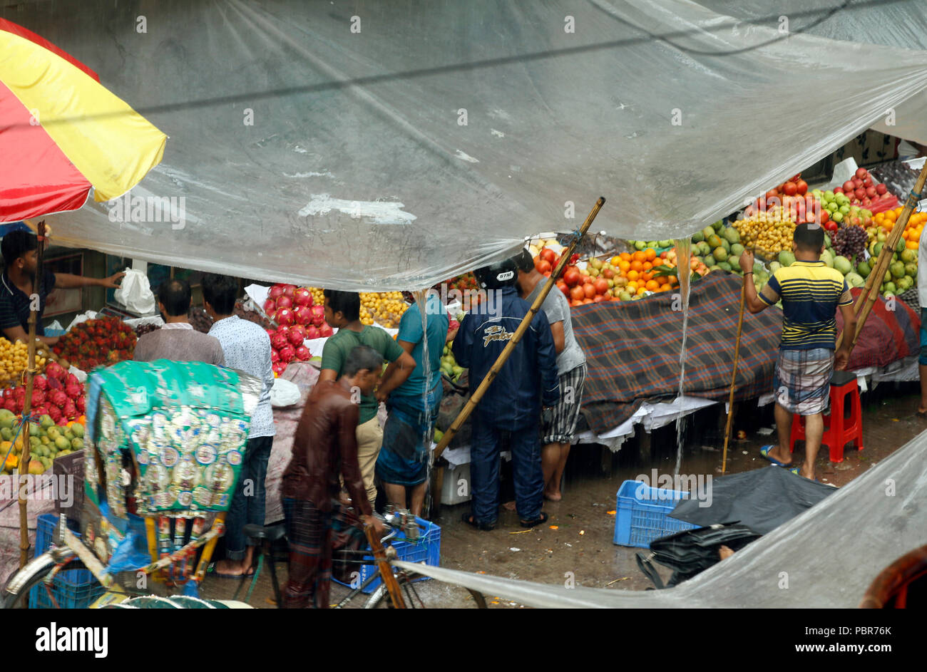 Abitanti della città catturati nella doccia pesante a capitale Purana Paltan area vicino National Baitul Mukarram moschea, Dhaka, Bangladesh. Luglio 24, 2018 Foto Stock