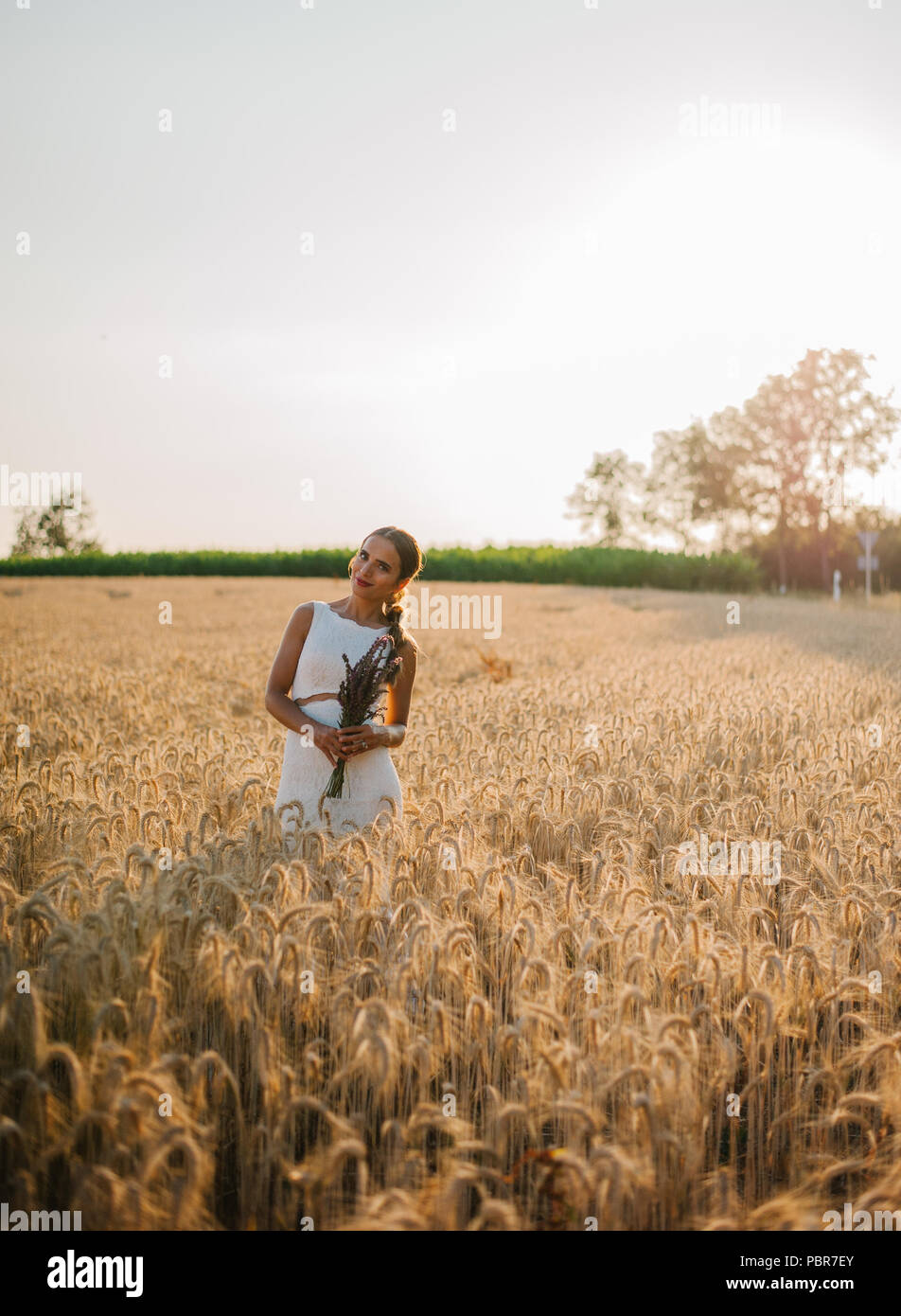 Sposa tiro con un mazzo di fiori in un campo Foto Stock