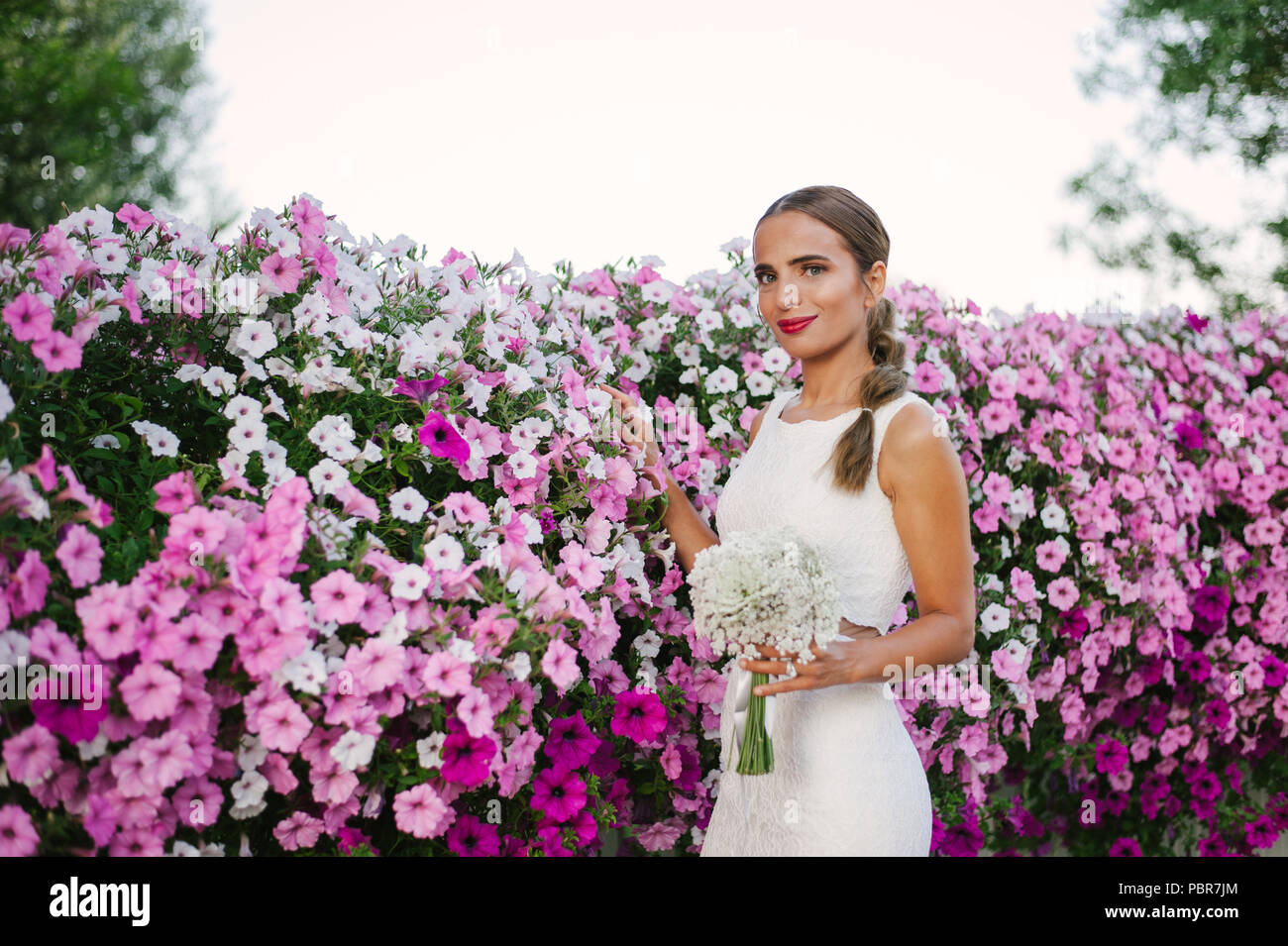 Sposa le riprese con i fiori vicino alla strada Foto Stock