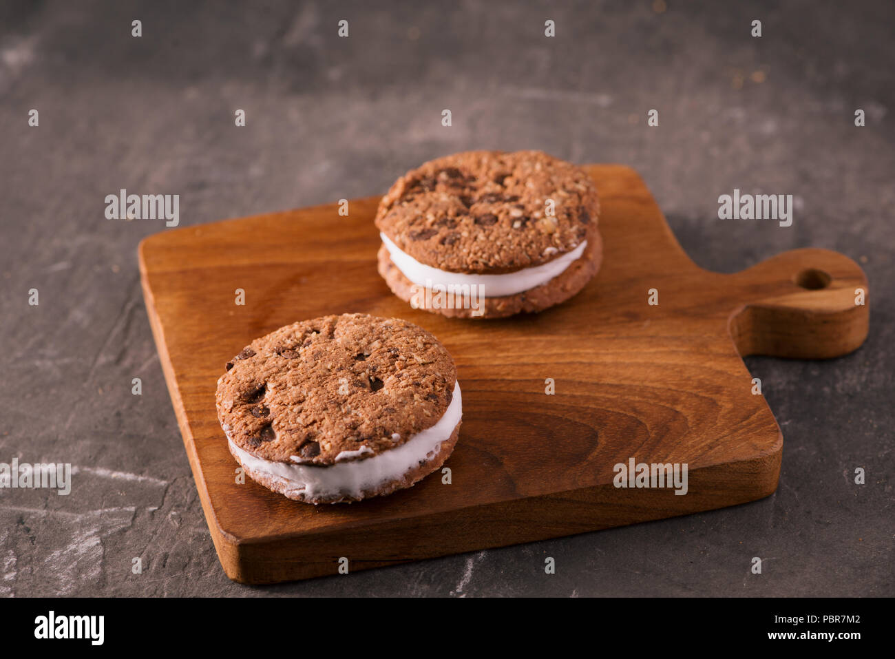 Cookie Ice Cream Sandwich isolati su tavola in legno rustico Foto Stock