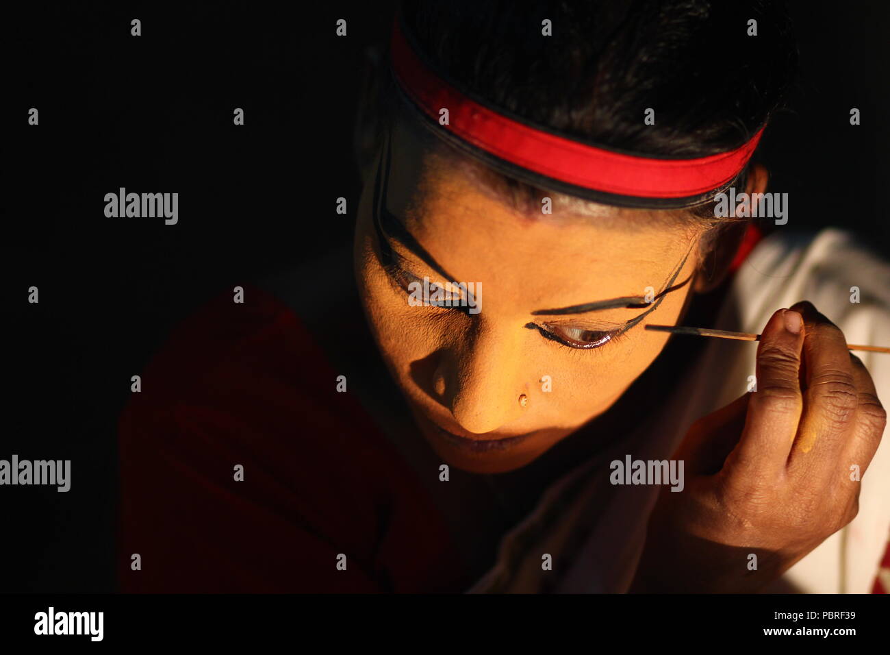 Un artista Koodiyattam ottenere pronto per le prestazioni mettendo la faccia della vernice. Artista messa faccia painint, artista Koodiyattam ottenere pronto ad eseguire. Foto Stock