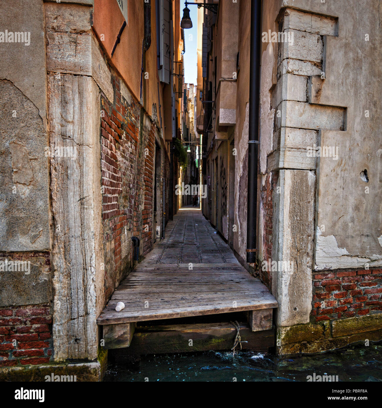 Un vicolo di passaggio tra due edifici a Venezia conduce all'accesso all'acqua Foto Stock