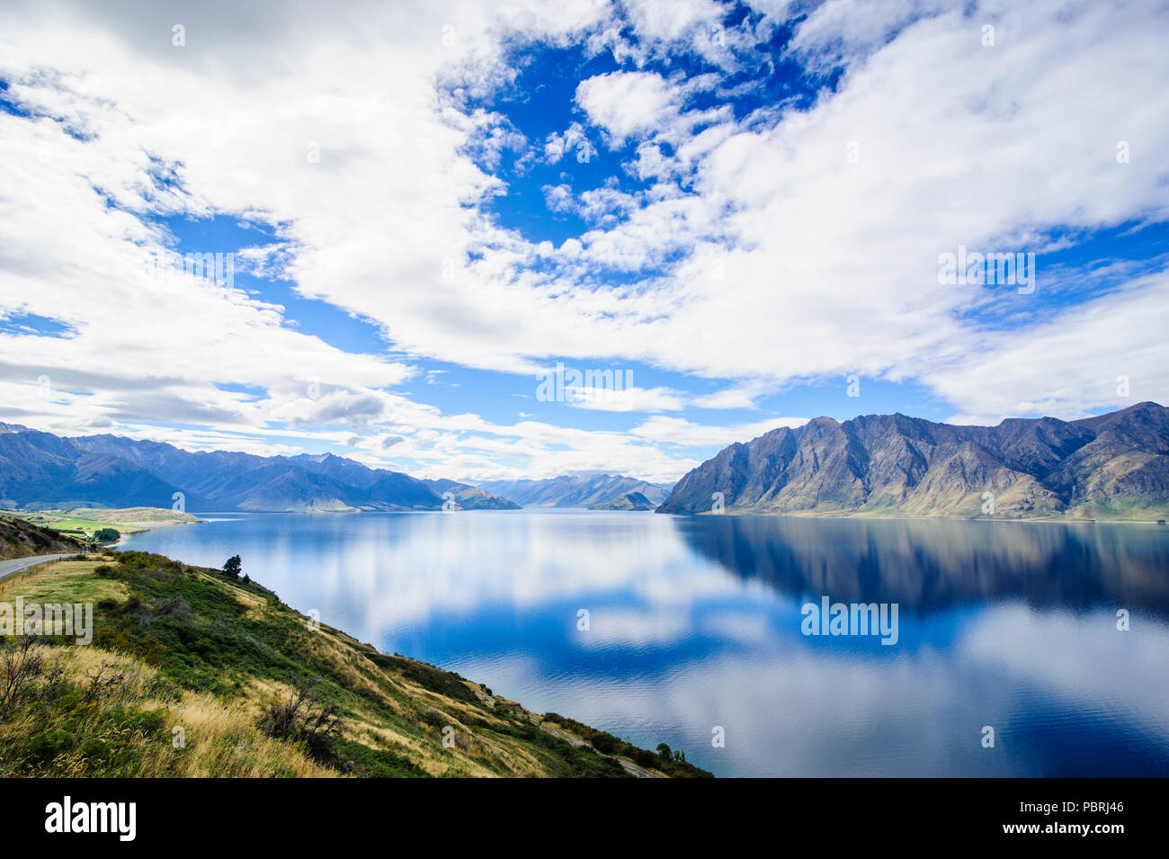 Cielo nuvoloso con acqua riflessi nel lago Hawea, Haast Pass, Isola del Sud, Nuova Zelanda Foto Stock