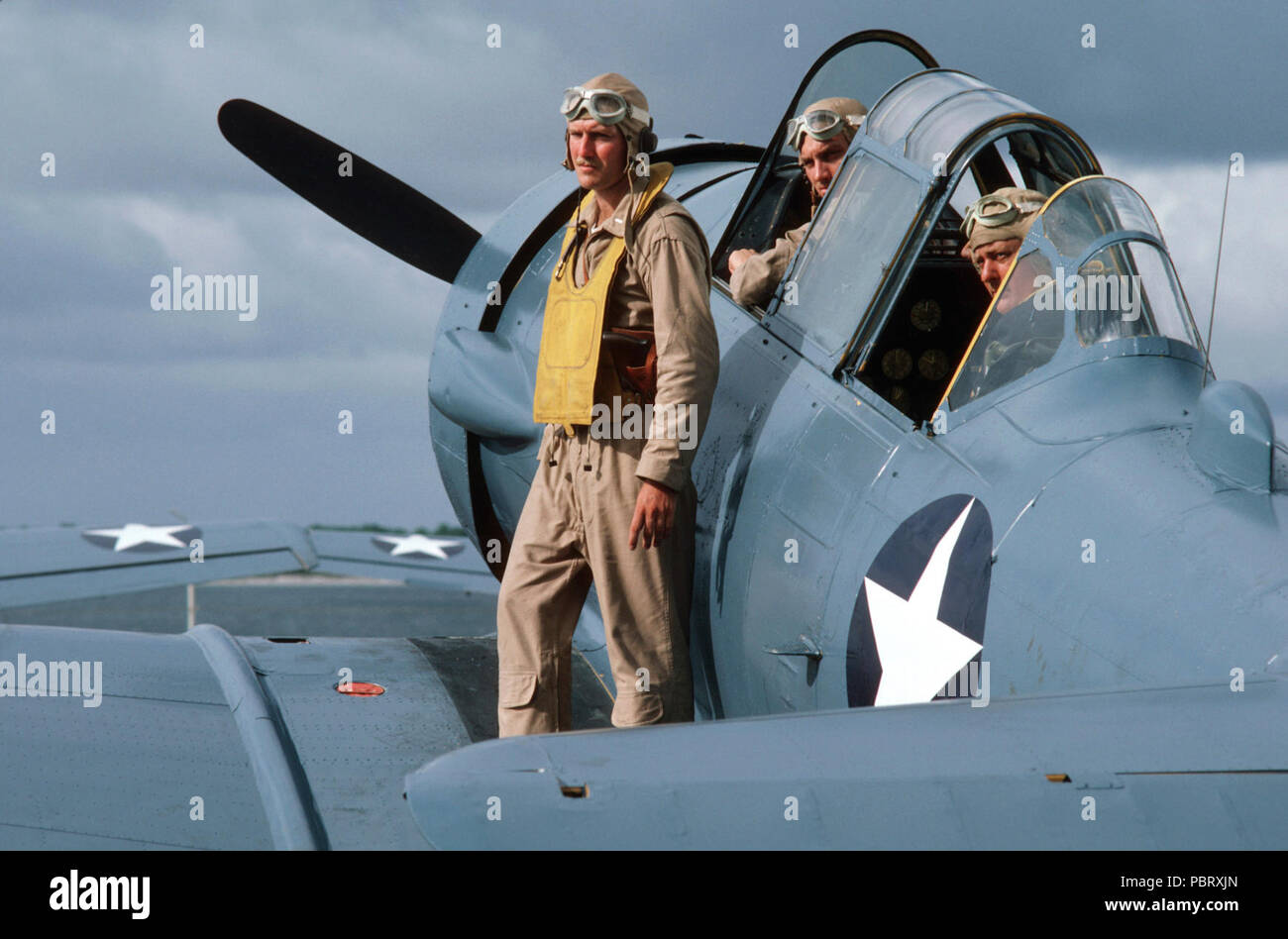 Gli attori sul T-6 texano a bordo della USS Lexington (AVT-16) durante la ripresa della guerra e Remenbrance 1987. Gli attori nella II Guerra Mondiale aviatore uniformi prendete la direzione dalla cima di un texano SNJ aeromobili parcheggiati sul ponte della formazione della portaerei USS Lexington (AVT 16) durante le riprese di ABC-TV movie "Guerra e ricordo. Foto Stock