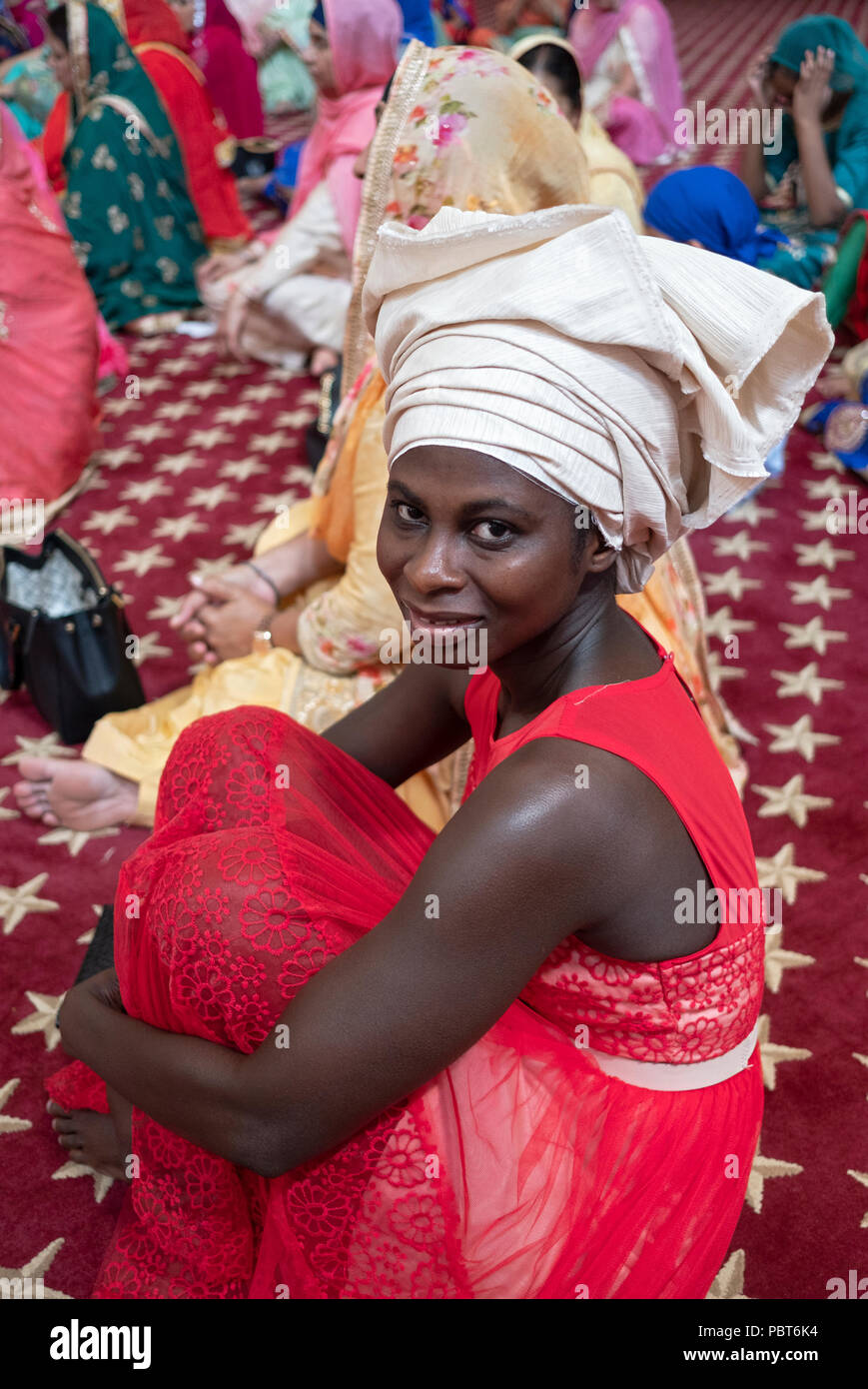 Un nigeriano ospite a un matrimonio Sikh indossando un tradizionale cappello nigeriano in Richmond Hill, Queens, a New York. Foto Stock