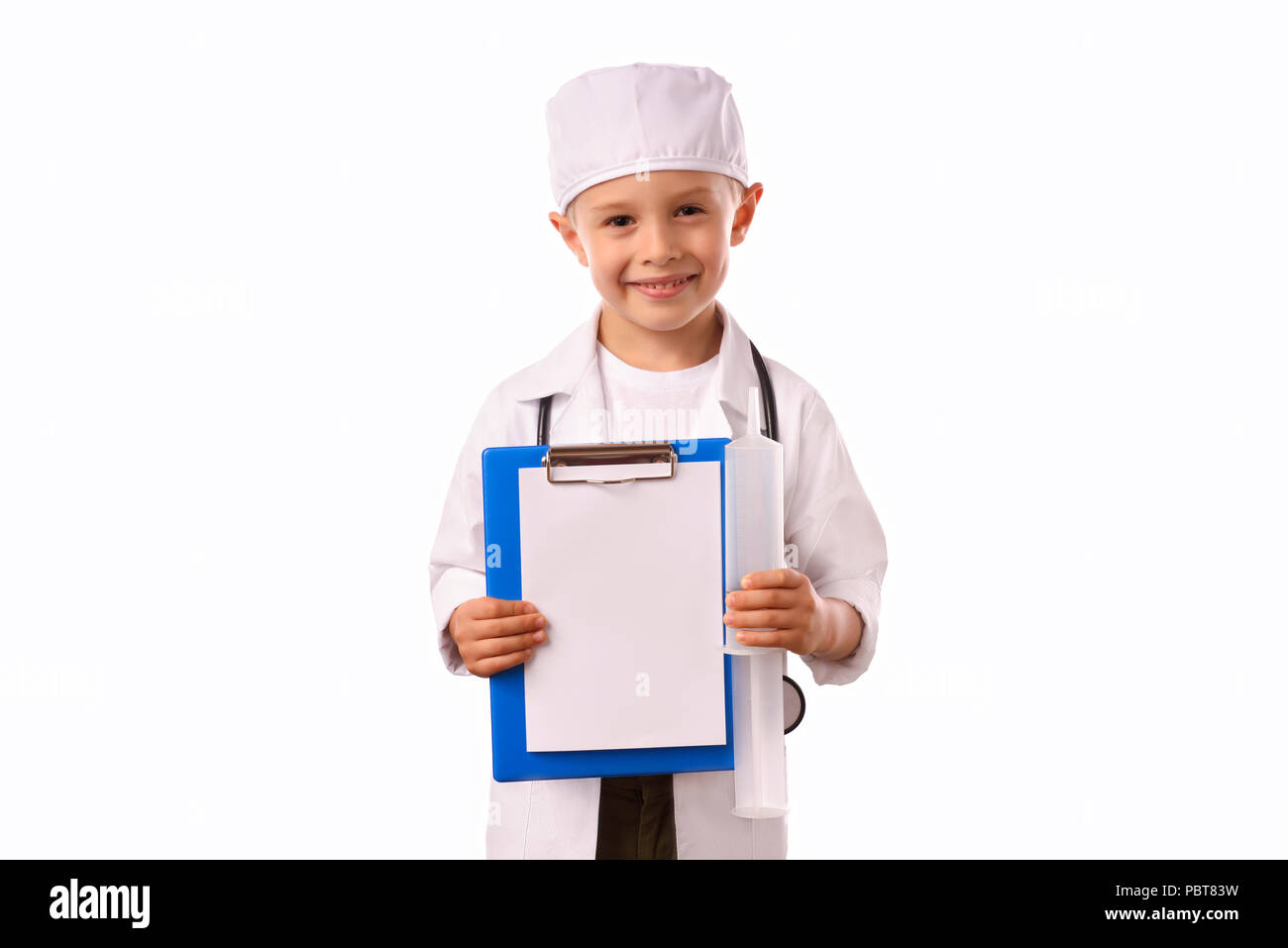 Un po', sorridente ragazzo dottore in medicina uniforme, isolato su bianco con uno stetoscopio sul collo, vi ricorda circa health care. Foto Stock