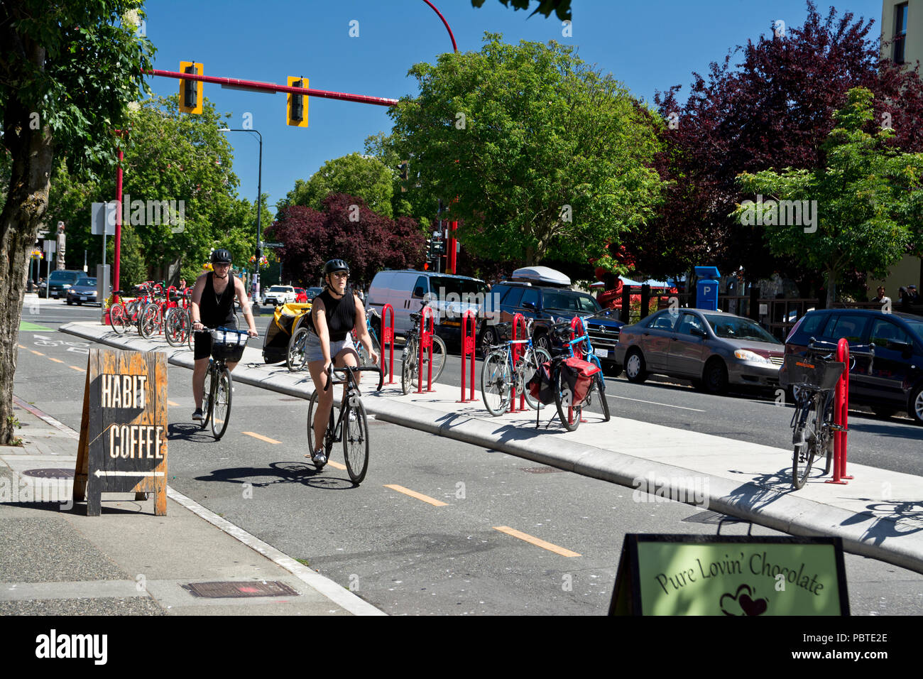 I ciclisti in sella a piste ciclabili nel centro cittadino di Victoria, British Columbia, Canada. Estate in bicicletta in Victoria BC Canada Foto Stock