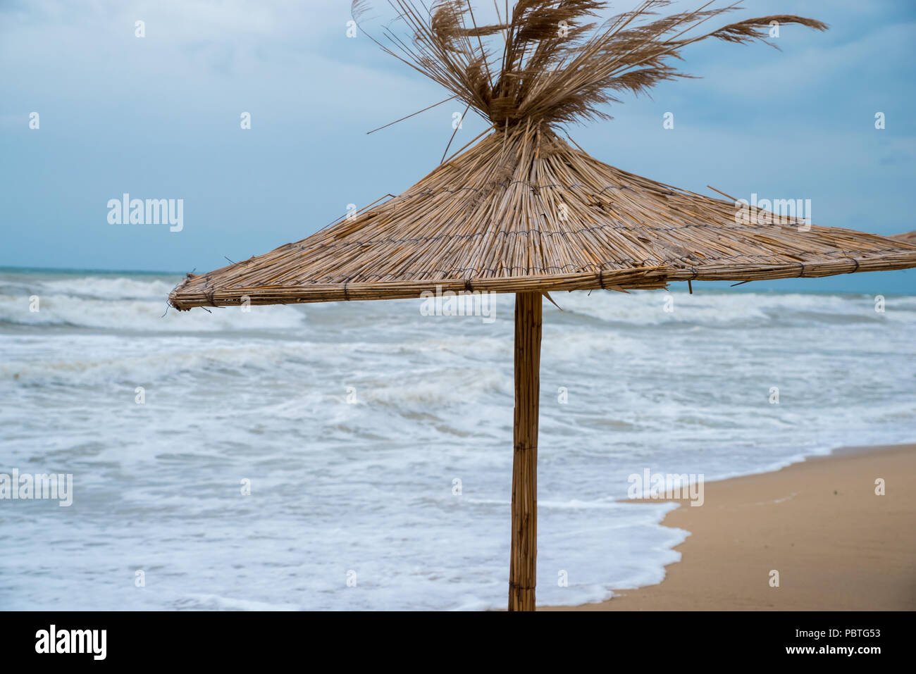 Ombrello di paglia sulla spiaggia. Foto Stock