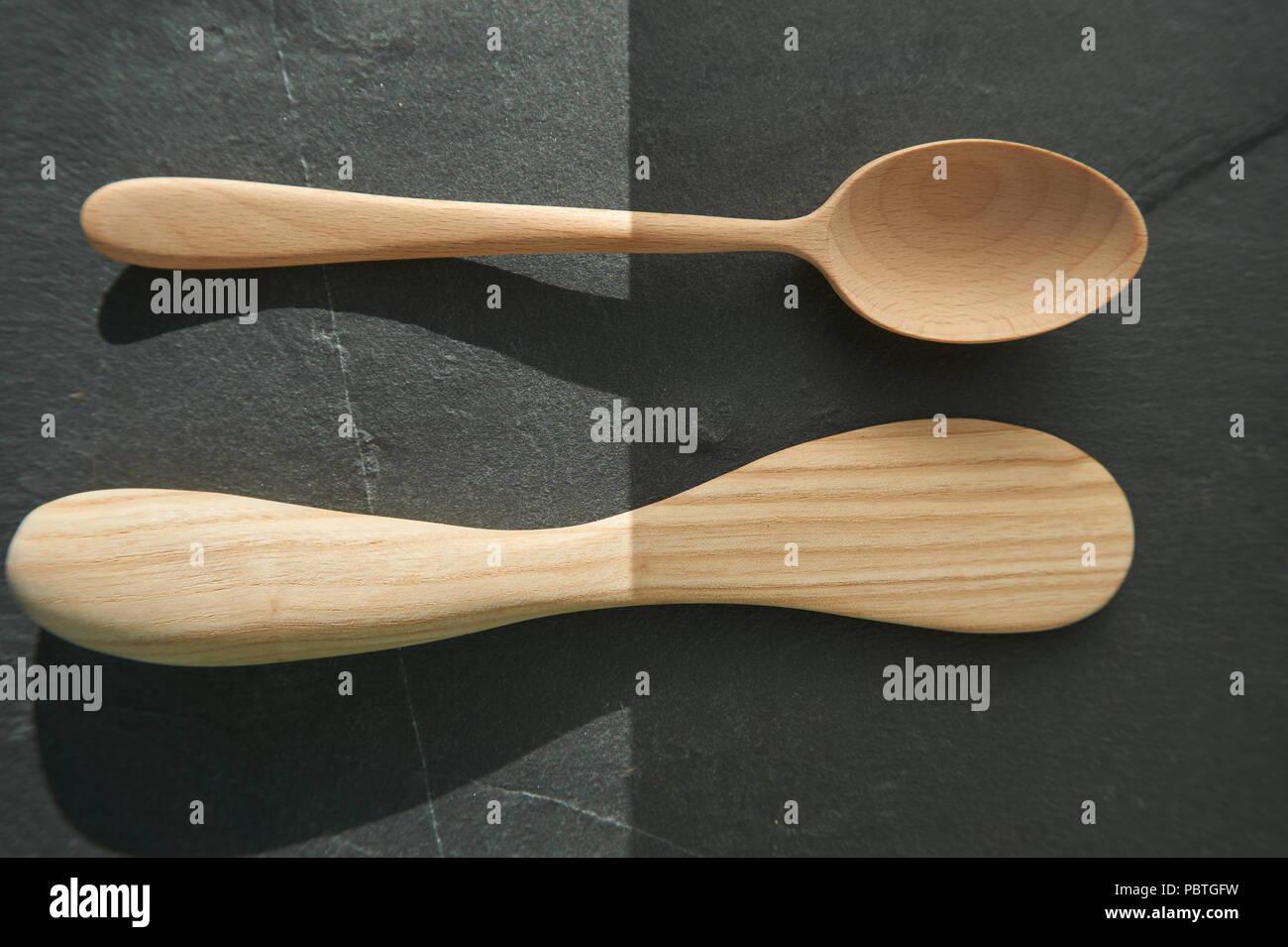 Close-up di un cucchiaio di legno e un rustico di arnese da cucina come concetto per semplicità o semplice cucina Foto Stock
