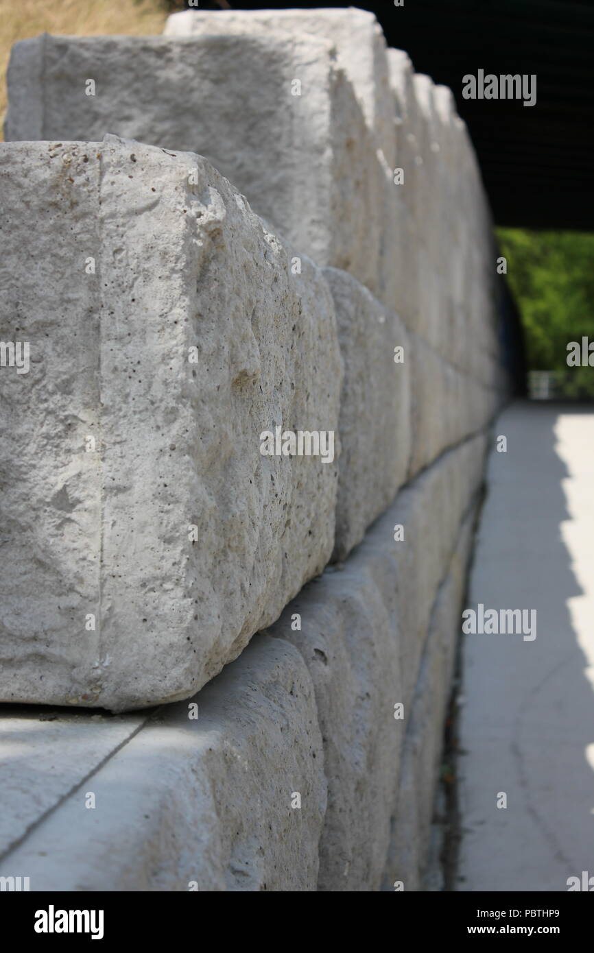 Una parete di mattoni di calcestruzzo che fiancheggiano il percorso. Foto Stock