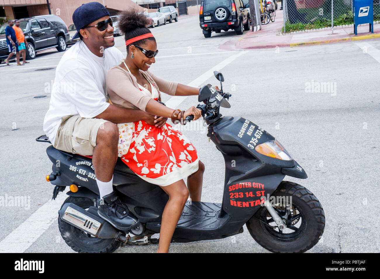 Miami Beach Florida, Ocean Drive, noleggio, scooter scooter a motore, neri  africani africani minoranza etnica, adulti uomo uomo uomini maschio, donna  donne fema Foto stock - Alamy