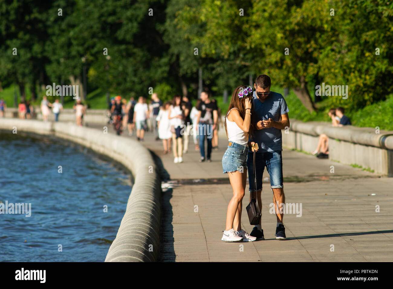 Mosca. Unidentified giovani uomini e donne andare lungo argine Puskin di Mosca Gorky Park, gode la calda e soleggiata giornata estiva. Foto Stock