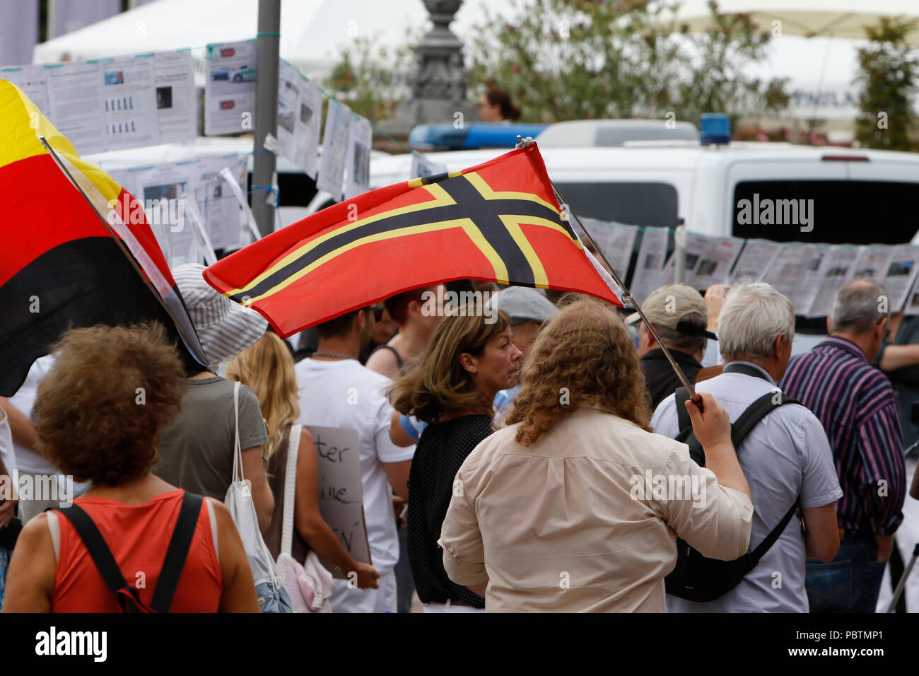 Wiesbaden, Germania. 29 Luglio, 2018. Un ala destra protester sventola una bandiera Wirmer. A destra i manifestanti di mano in mano - Gegen die Gewalt auf unseren Strasen (mano nella mano - contro la violenza sulle nostre strade) movimento tenuto un governo anti-rally di Wiesbaden. La protesta si è svolta sotto il pretesto di una veglia per l'adolescente Susanna F, che sarebbe stato ucciso da un rifugiato a Wiesbaden. Il rally è stato affrontato da diversi anti-casse del governo, che ha chiesto al governo di dimettersi. Credito: Michael Debets/Pacific Press/Alamy Live News Foto Stock