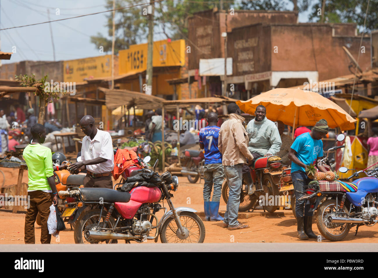 Piccola Città, Scene di strada, gli uomini con i motocicli, affollato mercato occupato, trasporti, Africa Orientale, Uganda Foto Stock
