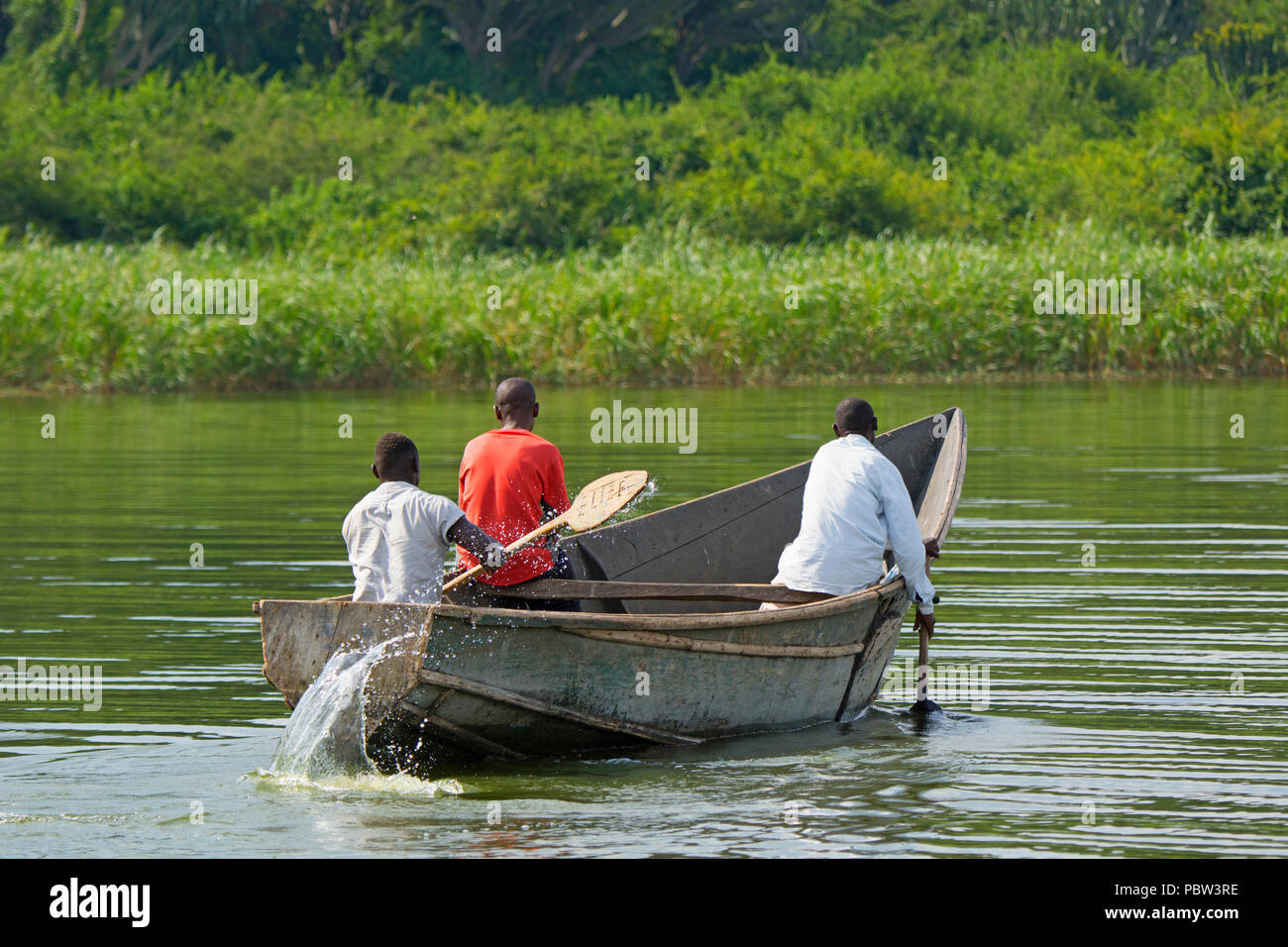 Tre Uomini in una barca, pescatori, Canottaggio Kayak lungo il canale Kazinga, Uganda, Africa orientale Foto Stock