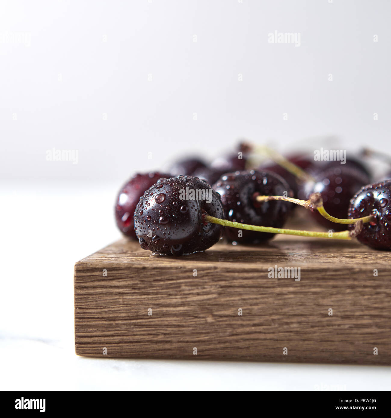 Home freschi coltivati in ciliegio con profondità di campo ridotta. Ingredienti per il dolce marmellata fatta in casa su un bordo. Foto Stock