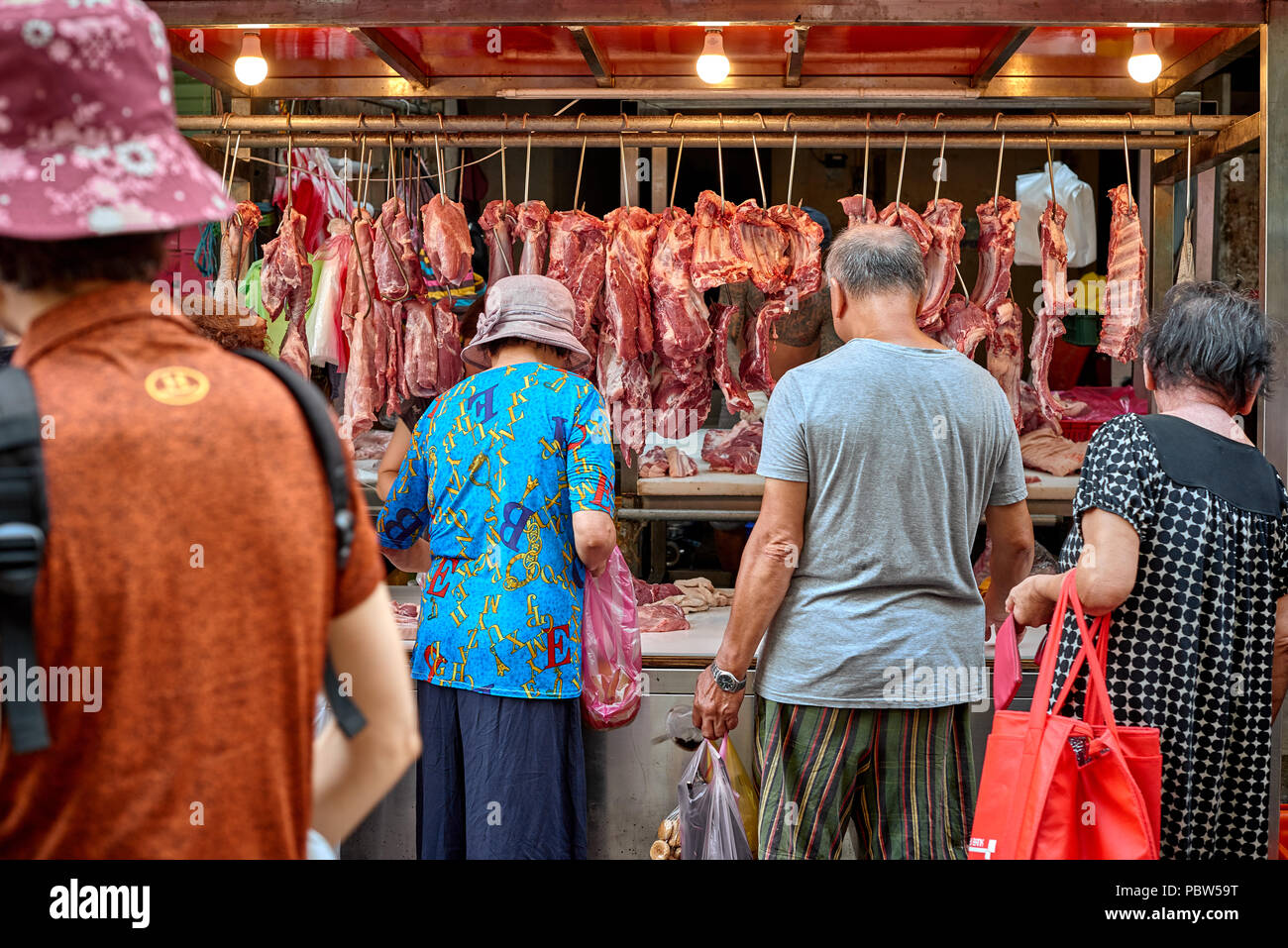 Asian anziani scegliere carni fresche da venditore ambulante Foto Stock