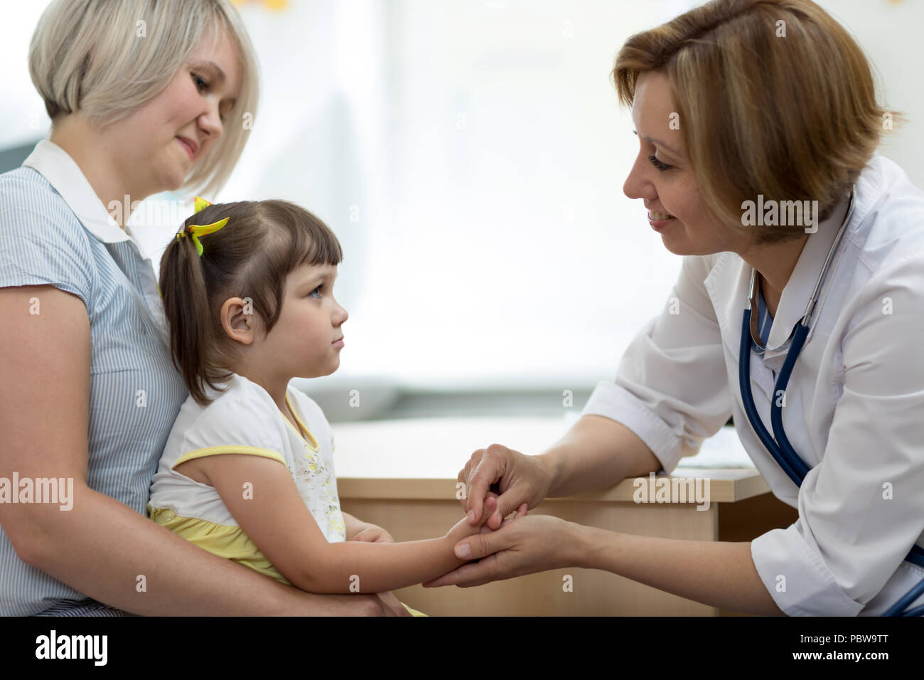 Sua madre e la sua piccola figlia al pediatra. Consulenza medico Donna con bambino. Foto Stock