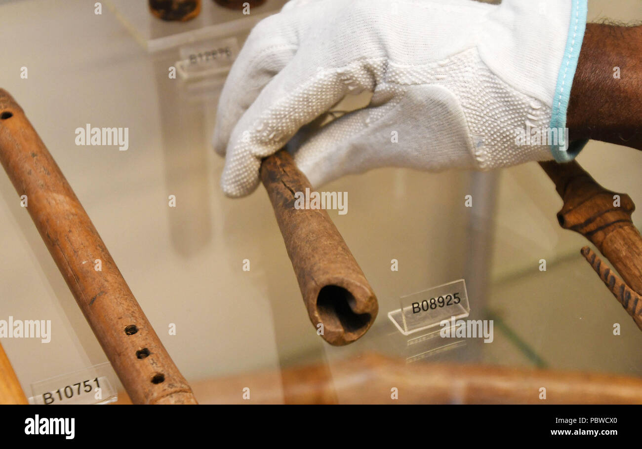 Bremen, Germania. 23 Luglio, 2018. Lo scienziato Ndzodo Awono restituisce un tubo dal Camerun al suo posto nel museo d'oltremare. Awono è che mostra le partecipazioni degli oggetti da collezione del Camerun. (A dpa 'commercializzati o rubato? - Übersee-Museum esplora il patrimonio coloniale' dal 30.07.2018) Credito: Carmen Jaspersen/dpa/Alamy Live News Foto Stock