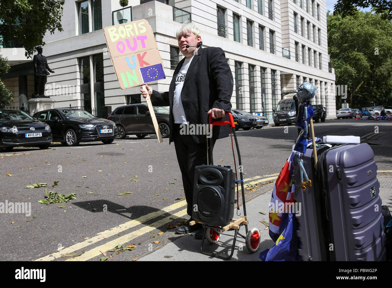 Giardini Carlton, Westminster, Londra, UK, 30 luglio 2018. Faux Bojo, completa di sacchetti in movimento (Drew Galdron, un Boris impersonator) gira fino al movimento di giorno per invogliare Boris fuori del residence. Distacco dei furgoni sono visto il carico di mobili e oggetti personali a ex Segretario di Stato per gli affari esteri Boris Johnson's London Residence in giardini Carlton, Westminster. Johnson aveva dovuto abbandonare la proprietà poiché scendendo dalla sua posizione ministeriale. Credito: Imageplotter News e sport/Alamy Live News Foto Stock