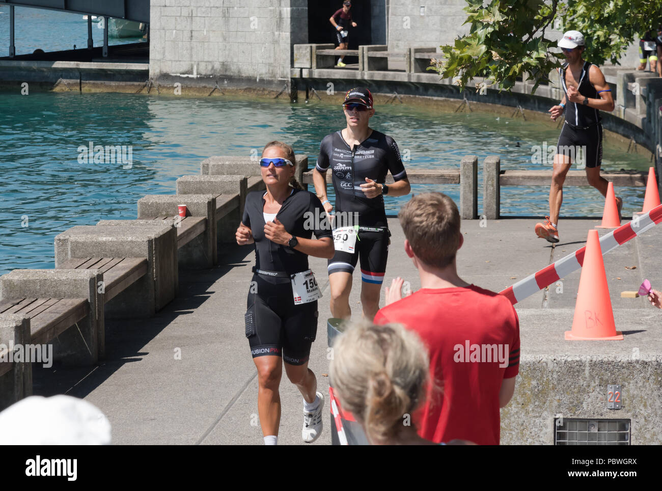 La Svizzera, 2018, Ironman Triathlon: Esecuzione di corso. Un concorrente che corre attraverso la città di Zurigo, Bellevue. Foto Stock