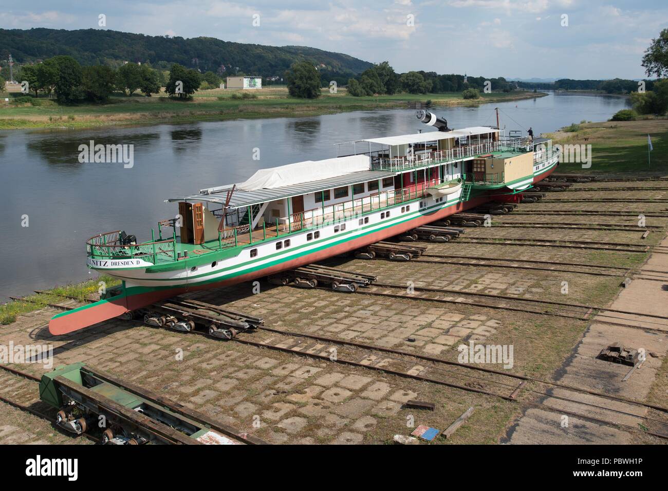 Dresden, Germania. Il 30 luglio, 2018. Lo storico battello a vapore "Pillnitz' è irrigato dopo dieci mesi di lavori di riparazione presso il cantiere di Laubegast. Per le attività logistiche Saechsische Dampfschiffahrt (lit. Saxon battello a vapore flotta) assume il vantaggio di una onda da parte ceca nel fiume Elba. Un livello di acqua di almeno 65 centimetri è richiesta per il lavoro. Credito: Sebastian Kahnert/dpa-Zentralbild/dpa/Alamy Live News Foto Stock