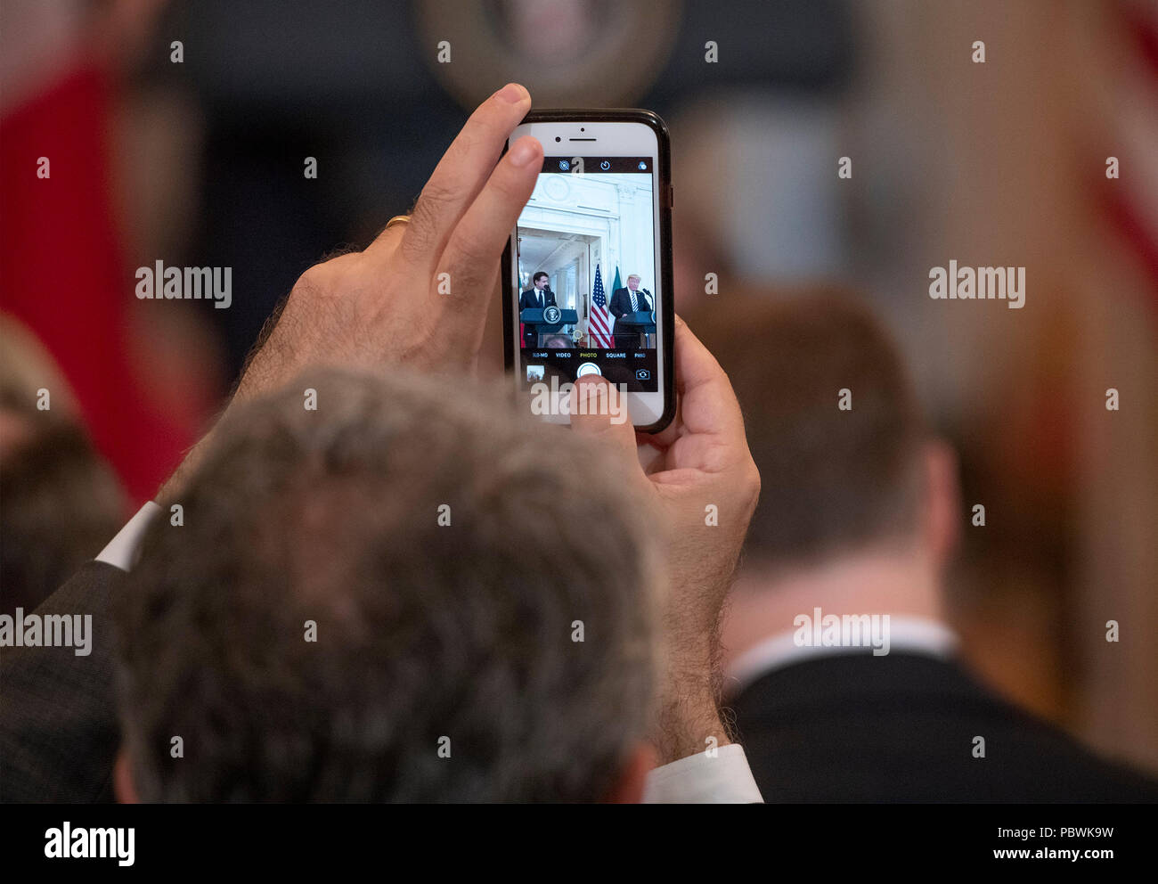 Un reporter richiede un iPhone foto come presidente degli Stati Uniti Trump, destro, e il Primo Ministro Giuseppe Conte d'Italia, sinistra, tenere una conferenza stampa congiunta nella Sala Est della Casa Bianca di Washington, DC il lunedì, 30 luglio 2018. Credito: Ron Sachs / CNP | Utilizzo di tutto il mondo Foto Stock