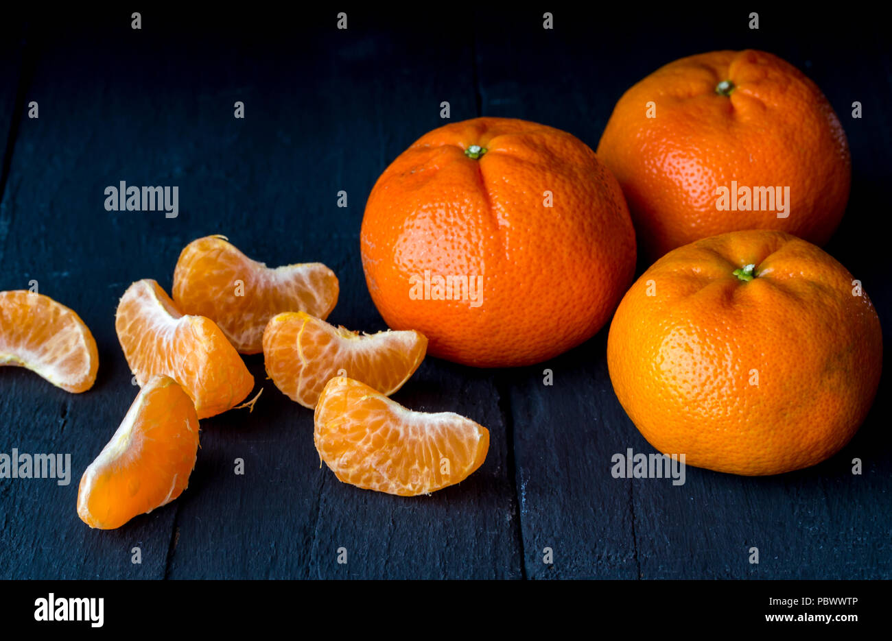 Tangerini rustico tavola nera close up - Agrumi sfondo Foto Stock
