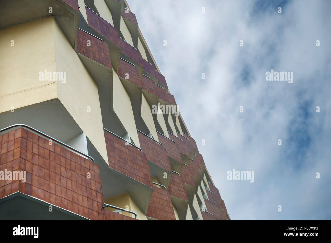 Vista dalla parte inferiore della facciata di un edificio residenziale nella città tedesca di Colonia sullo sfondo di un cielo nuvoloso Foto Stock