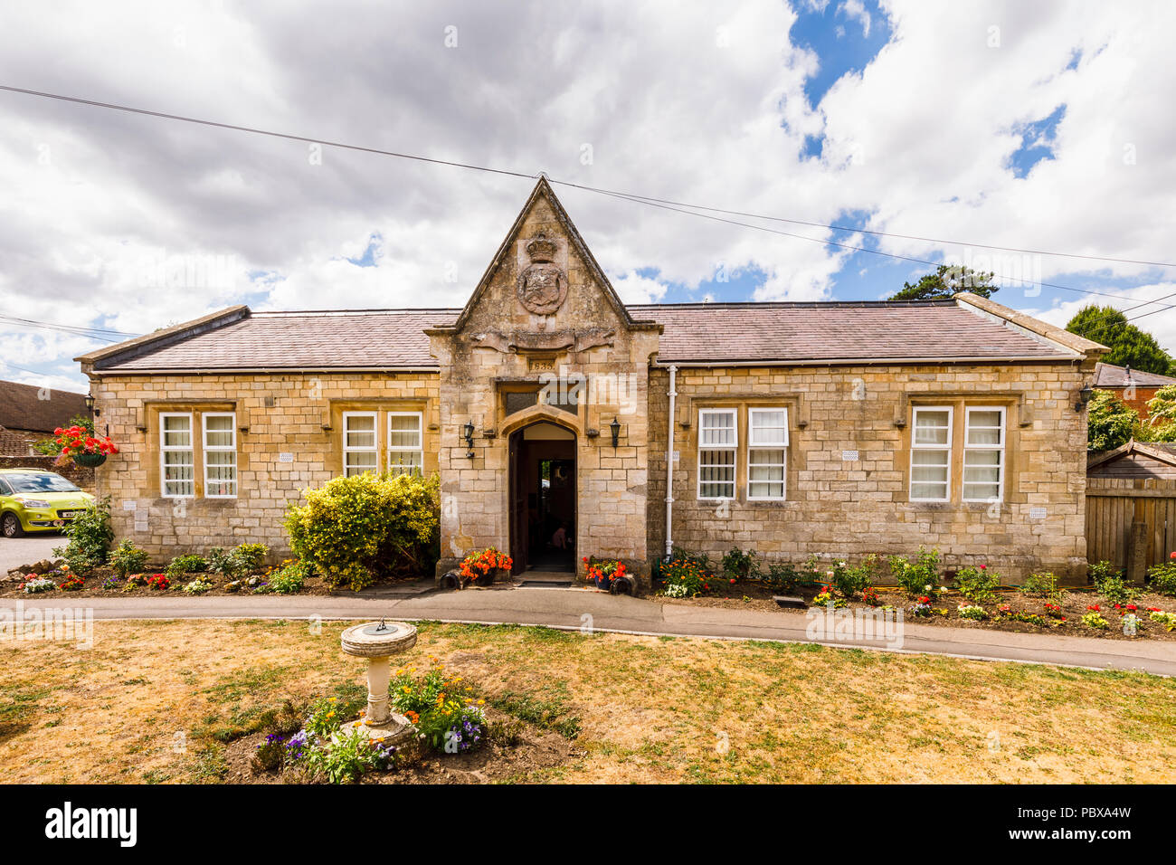 La vecchia scuola datata 1835, un edificio storico ora un presidio medico, grande Bedwyn, un villaggio rurale nel Wiltshire, Inghilterra del sud in estate Foto Stock