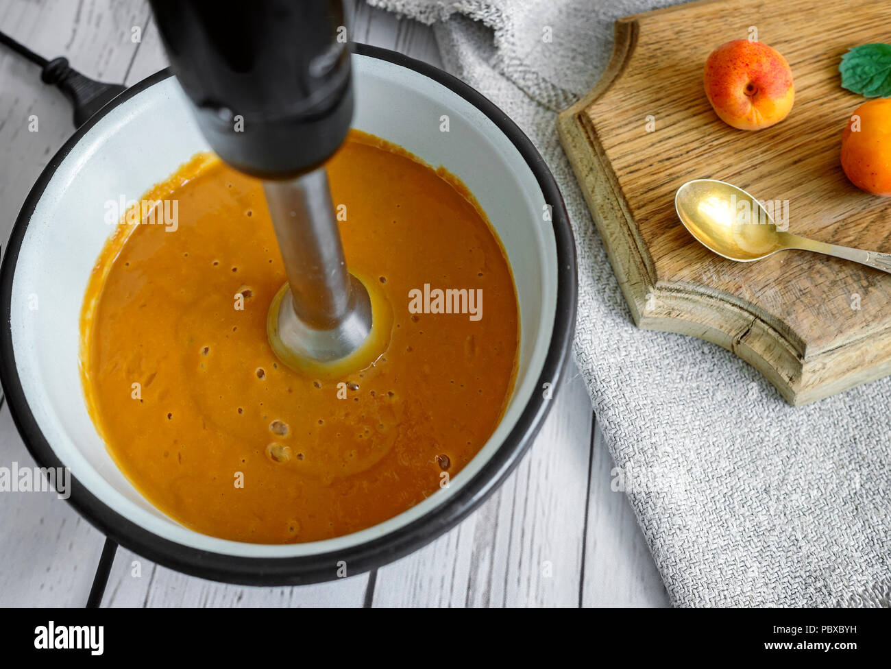 In una ciotola, utilizzando un frullatore, preparare frullati di albicocche. Foto Stock