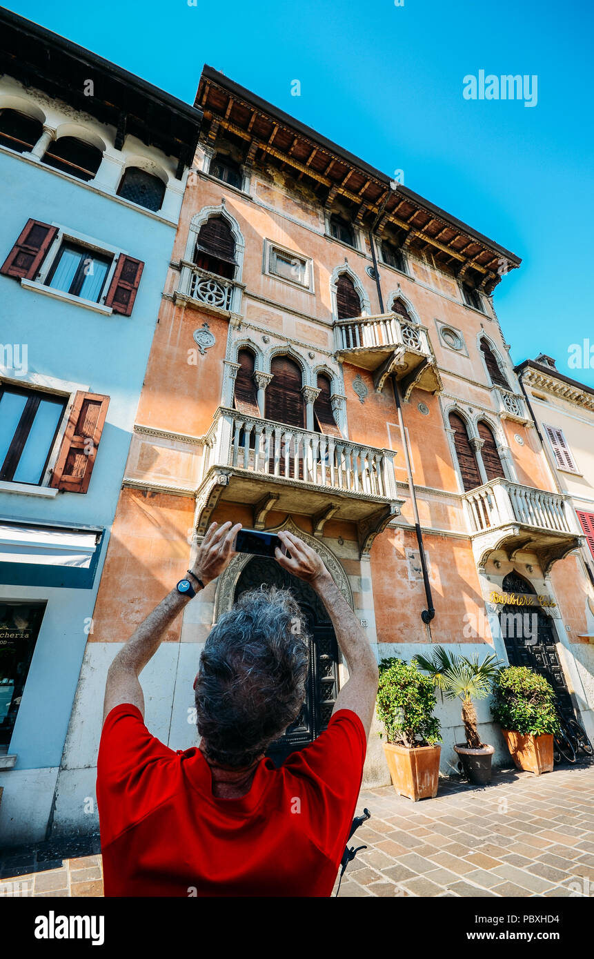 Ampio angolo di visione dell uomo di scattare una foto di un tradizionale stile Veneziano di architeture close up sulla facciata di edificio Foto Stock