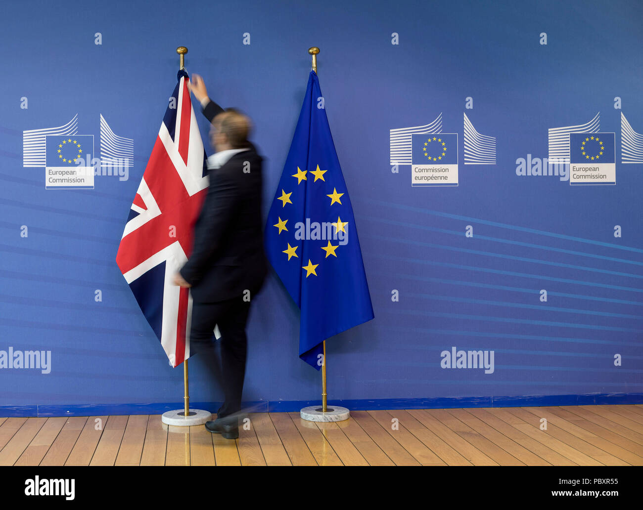 Il Belgio, Bruxelles: Inglese e bandiere europee in occasione dei colloqui Brexit. L'uomo la rimozione della bandiera inglese Foto Stock