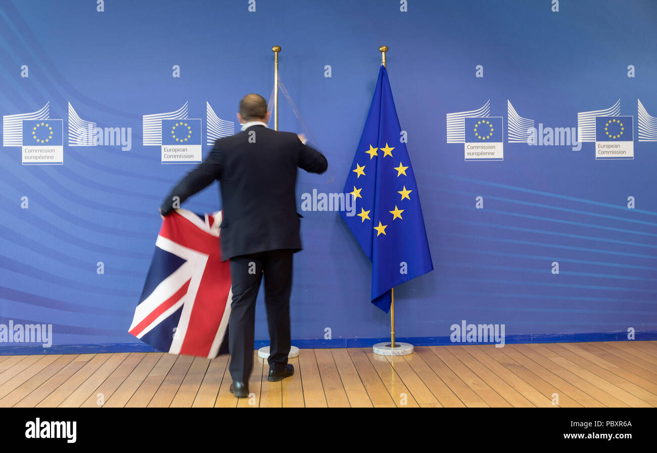 Il Belgio, Bruxelles: Inglese e bandiere europee in occasione dei colloqui Brexit. L'uomo la rimozione della bandiera inglese Foto Stock